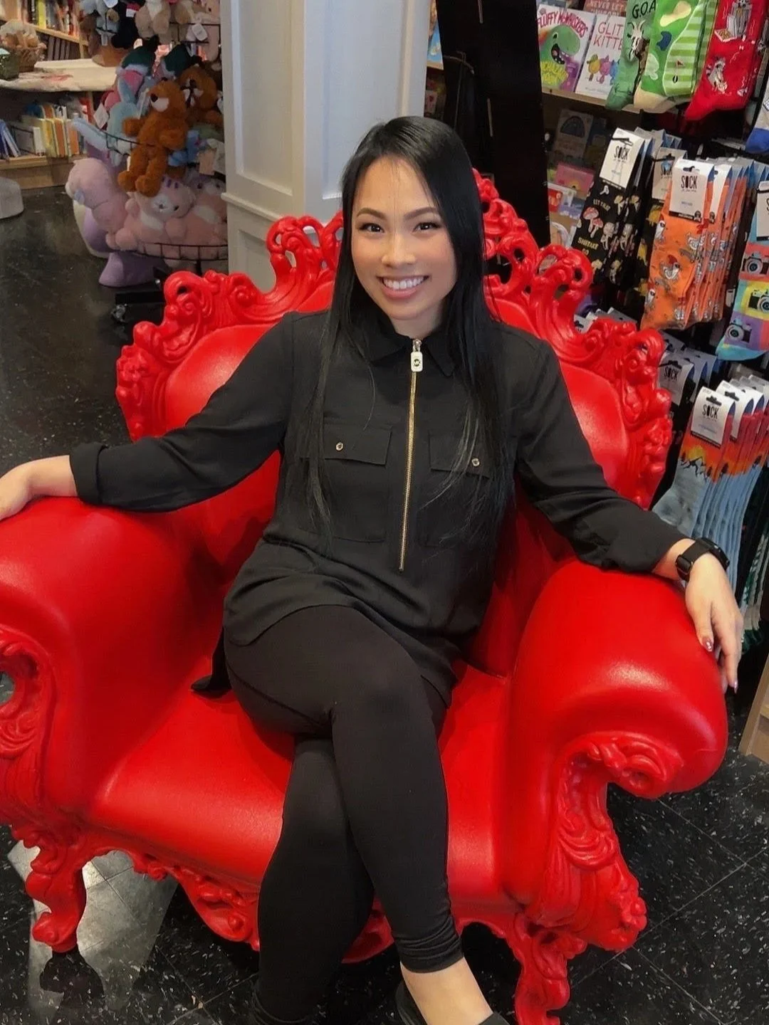 PR Team Member sitting in a large red, throne-like chair.