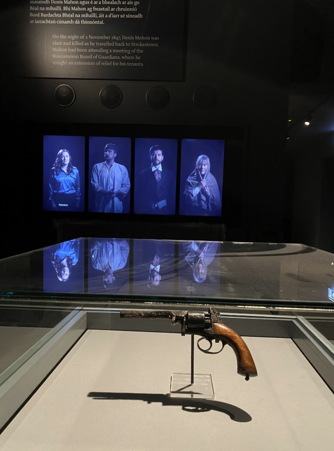 Digital background showing a 3d set with glass and a scale cartoonish scale model lit by spotlights