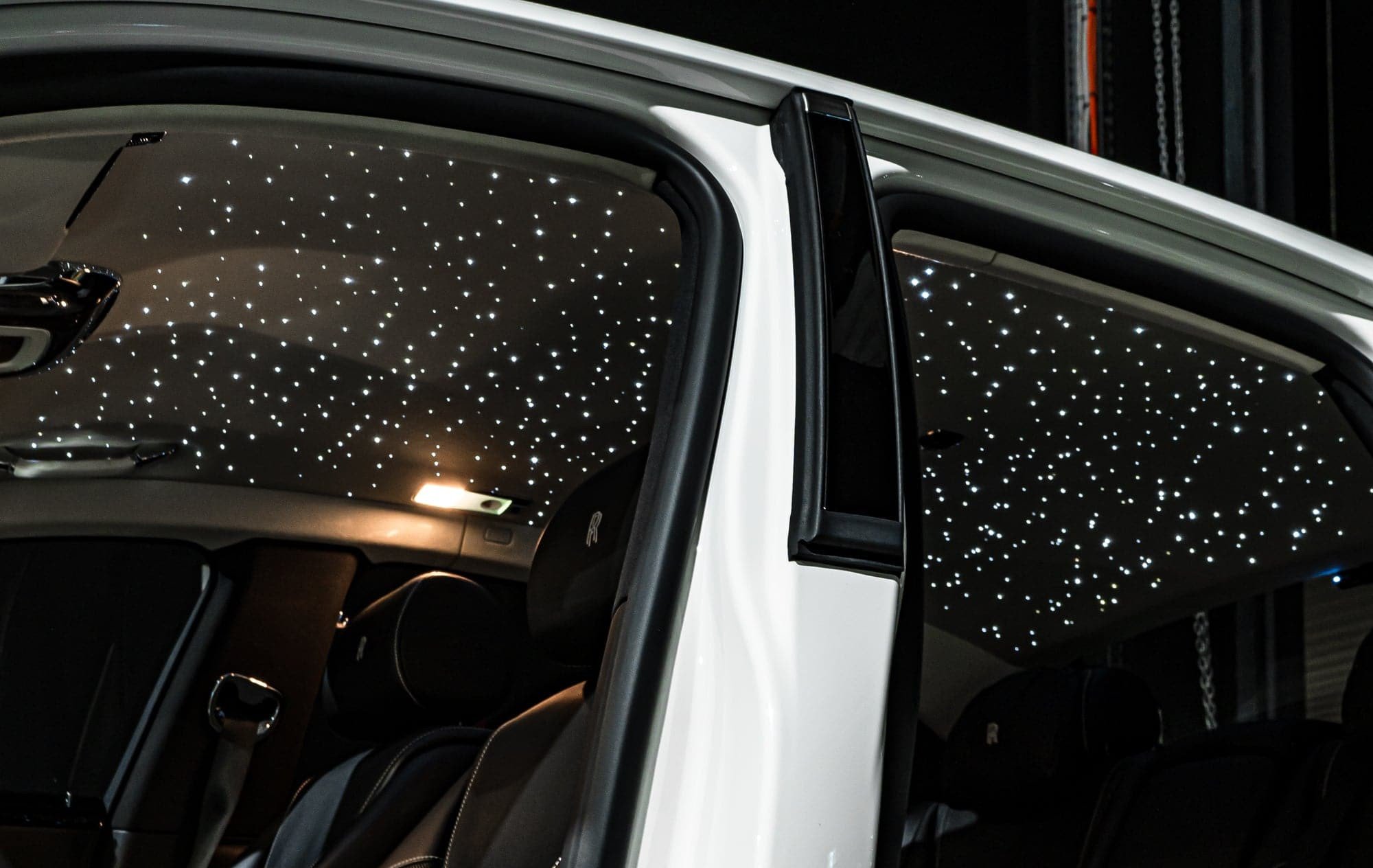 Interior of a luxury car with a starry night ceiling lights.