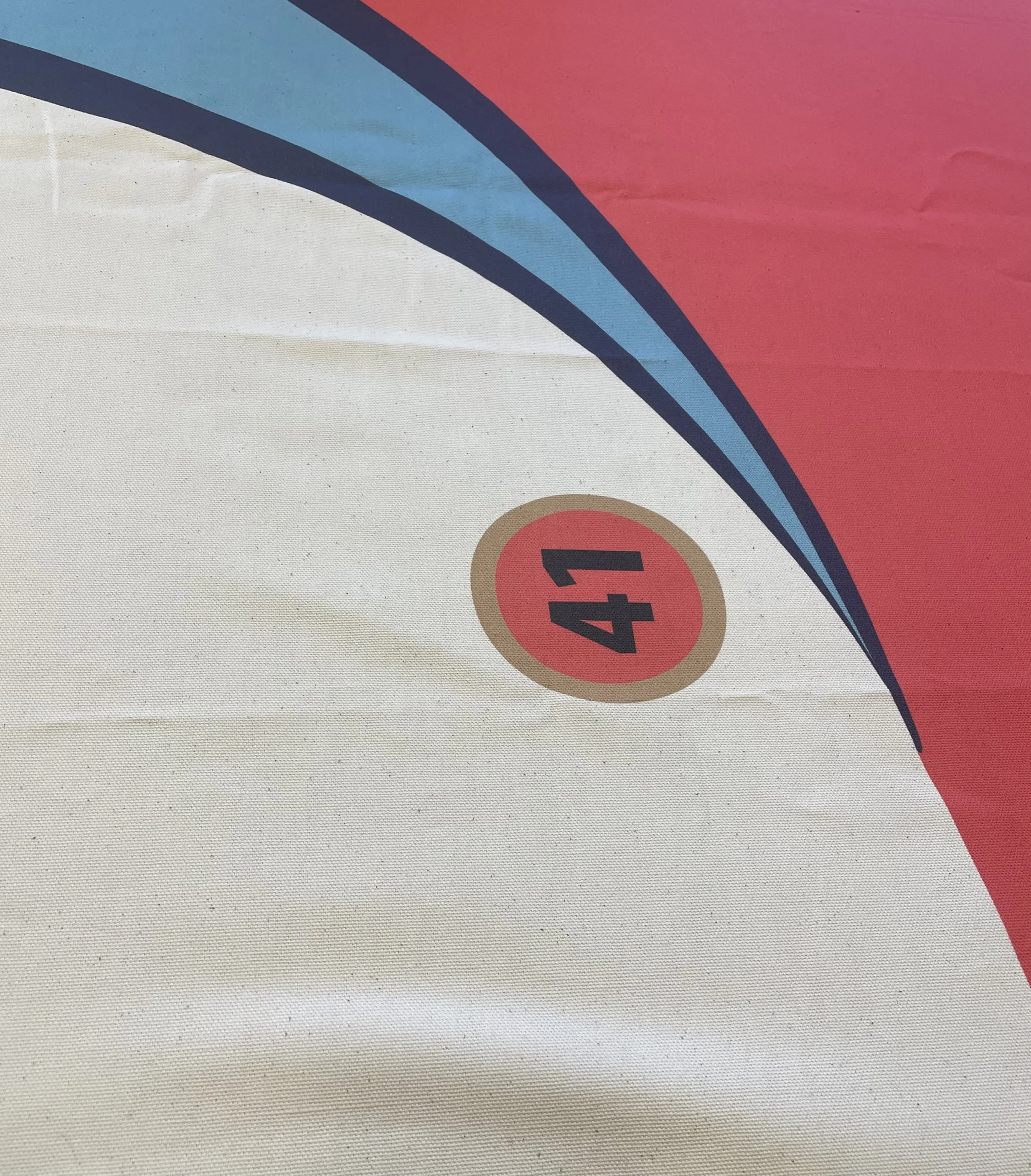Close-up of a poster with a red circle containing the number 41, partially visible pink and blue curved design.