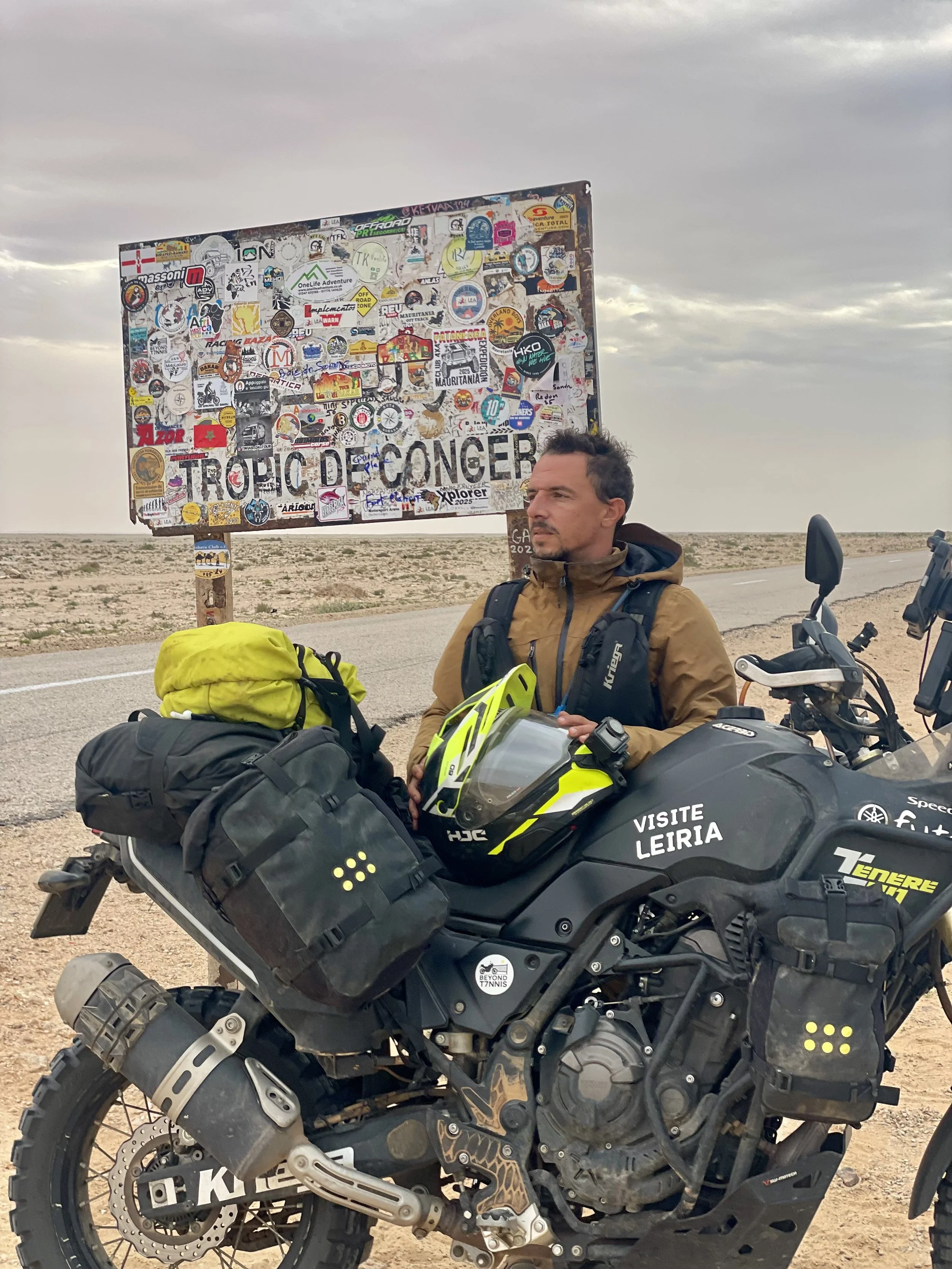 João Beltrão founder of Beyond T7nnis with his Yamaha Ténére 700 motorcycle at Tropic de Concer sign