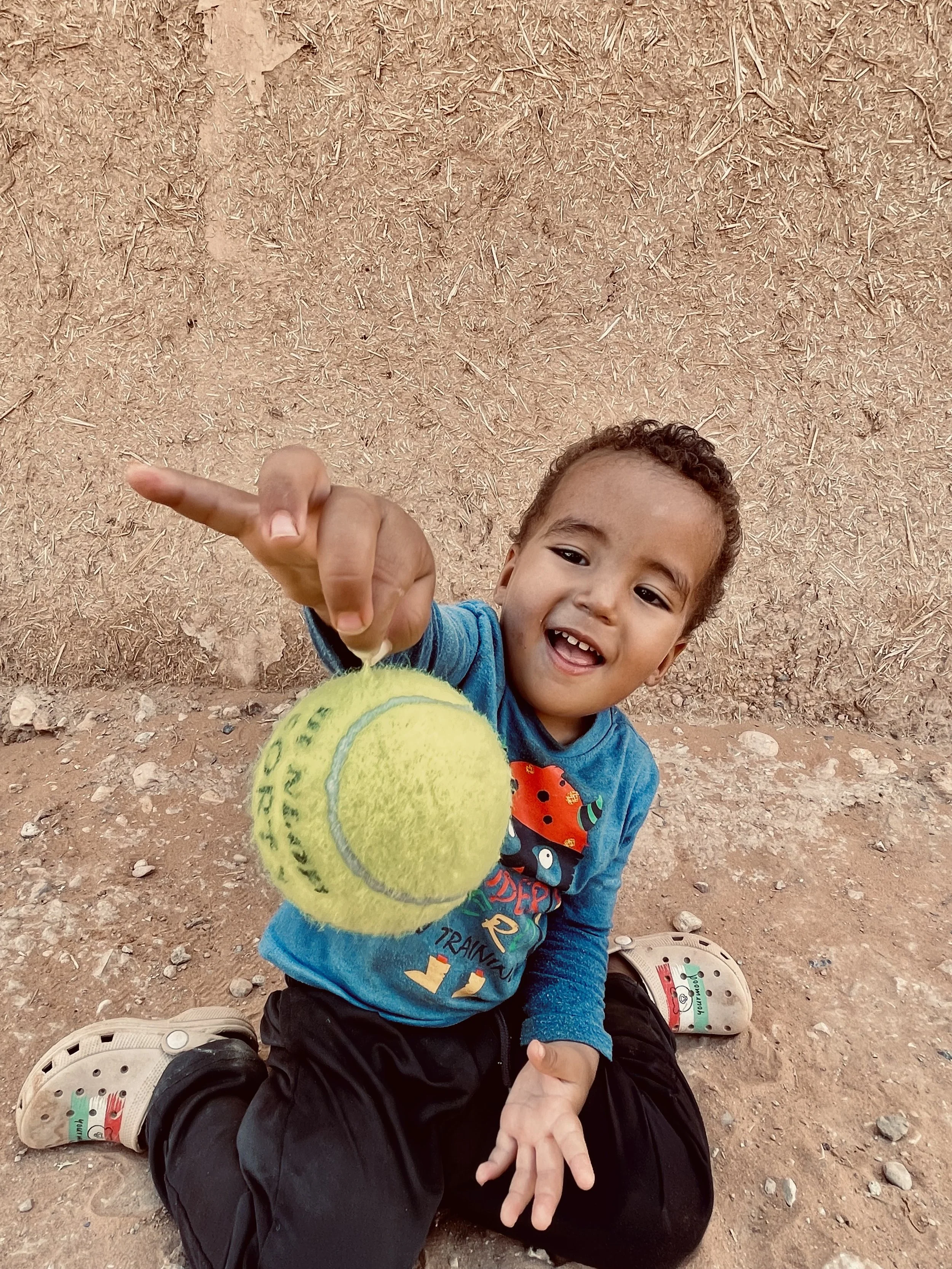 Kid holding a tennis ball for the first time in Ouzina, Morocco, during a Beyond T7nnis mission
