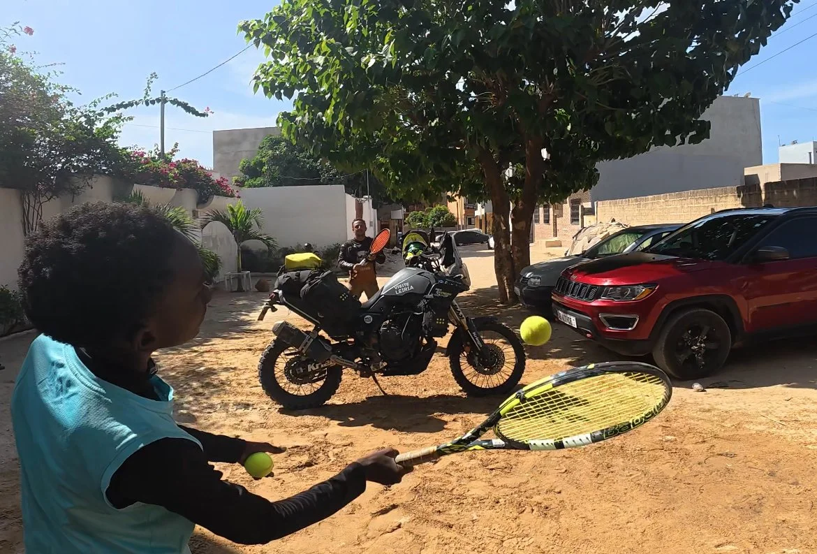 Kids playing tennis over a Yamaha Ténére 700 motorcycle during a Beyond T7nnis mission
