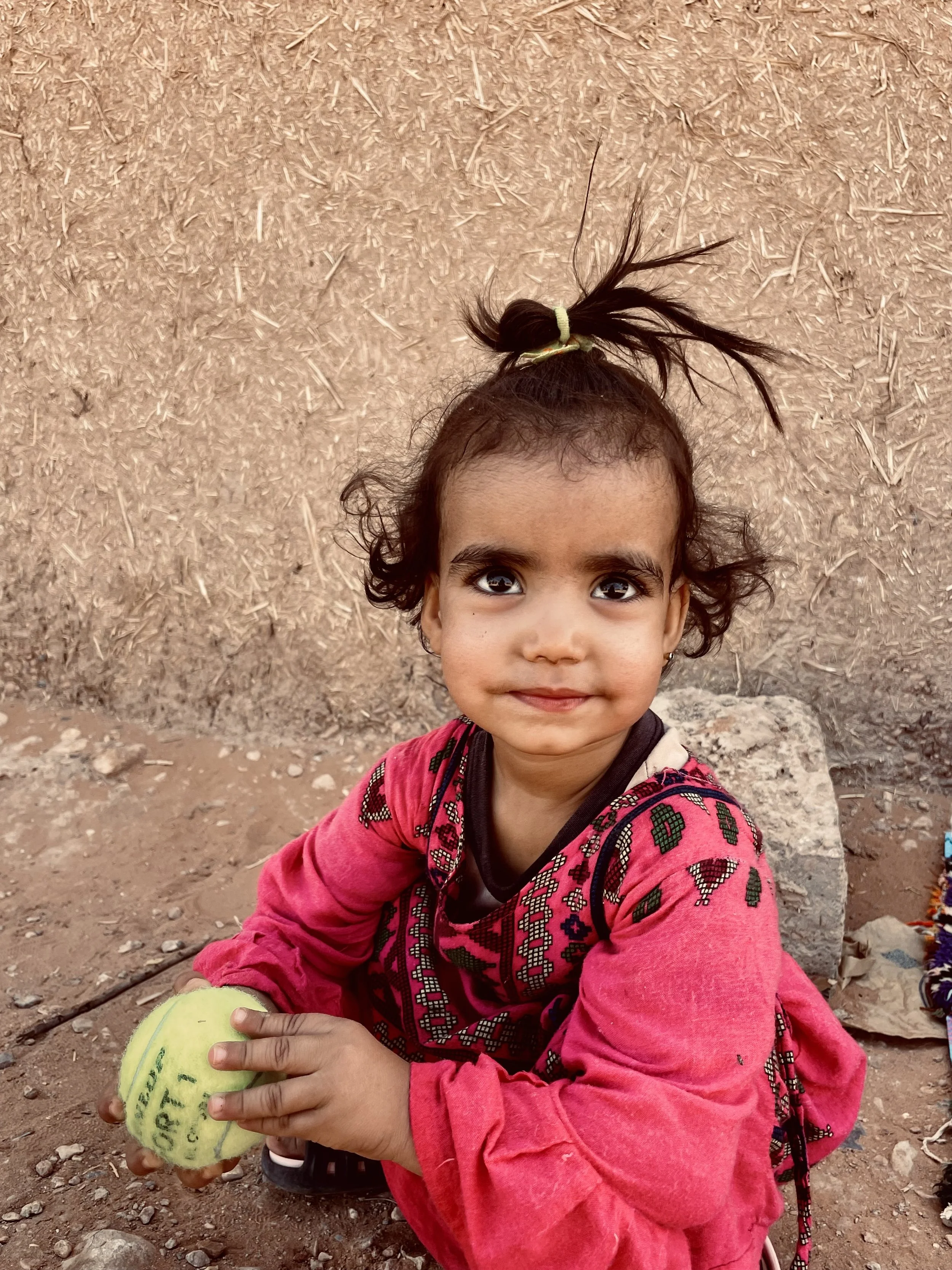 Kid holding a tennis ball for the first time in Ouzina, Morocco, during a Beyond T7nnis mission