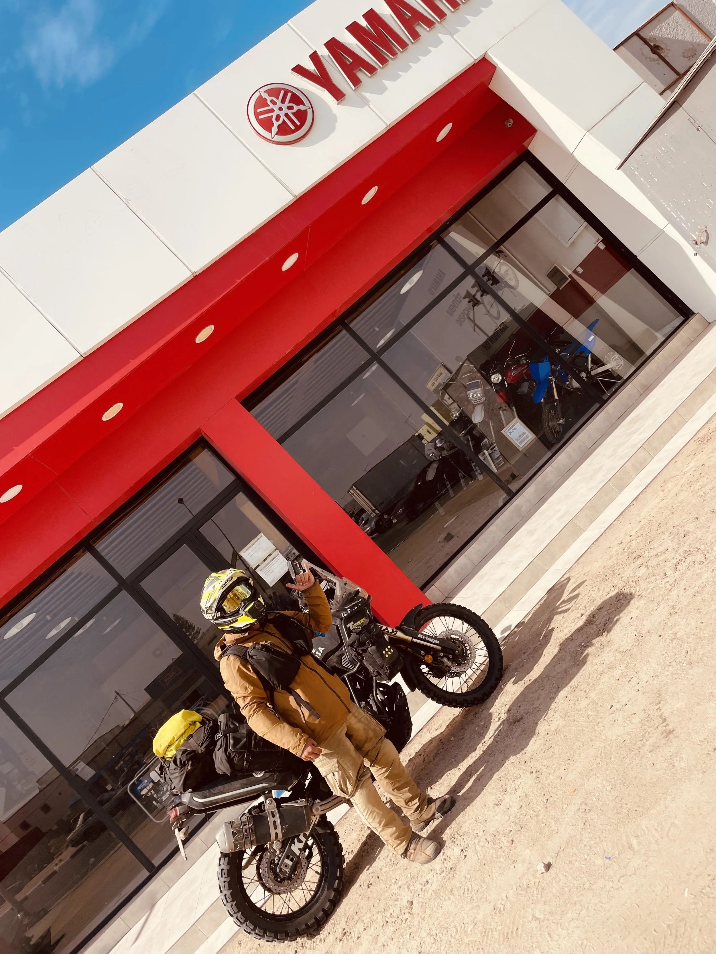 João Beltrão founder of Beyond T7nnis with his Yamaha Ténére 700 motorcycle in front of a Yamaha dealer in Nouakchott, Mauritania