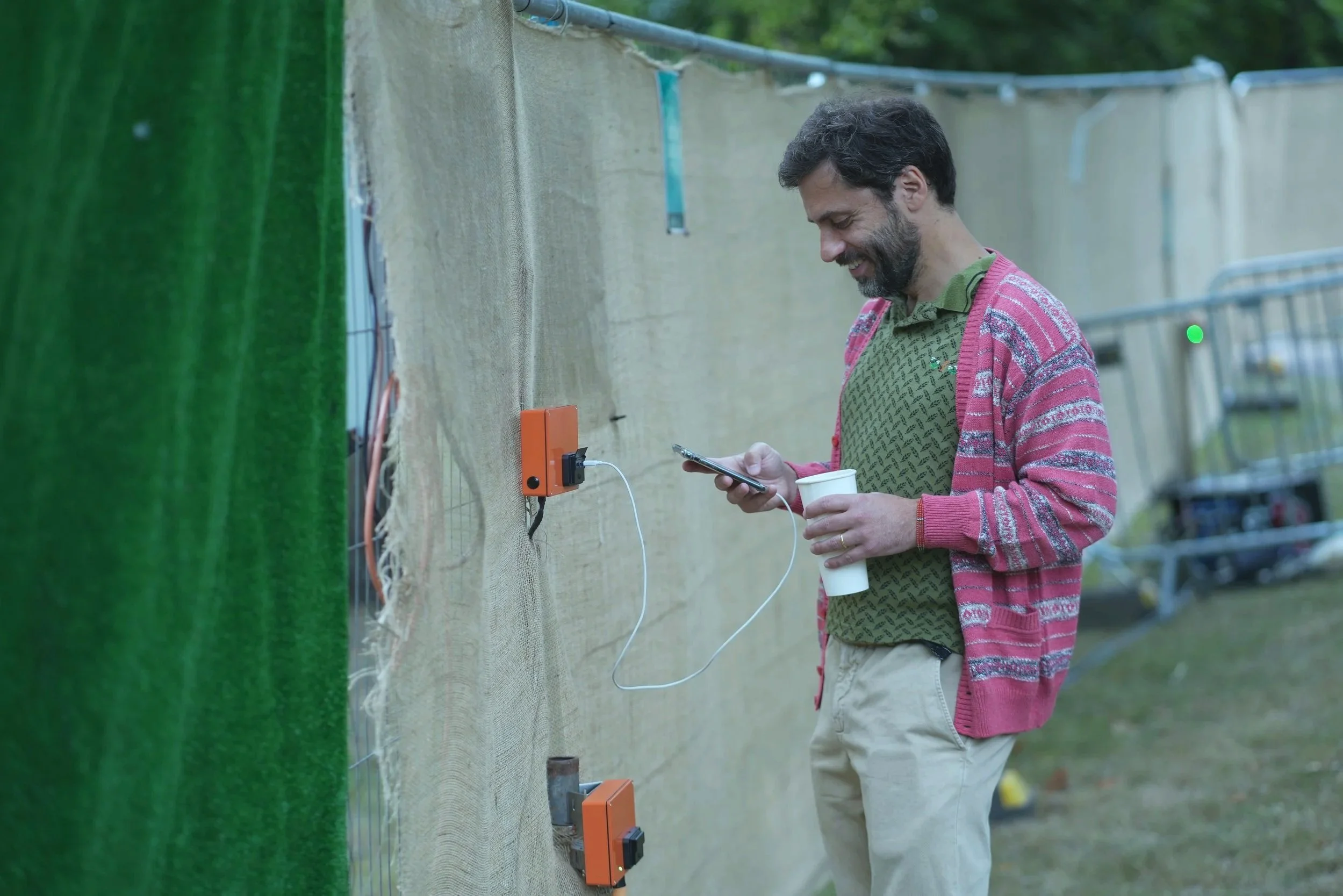 A man using a mobile phone while charging from a solar power off grid charger