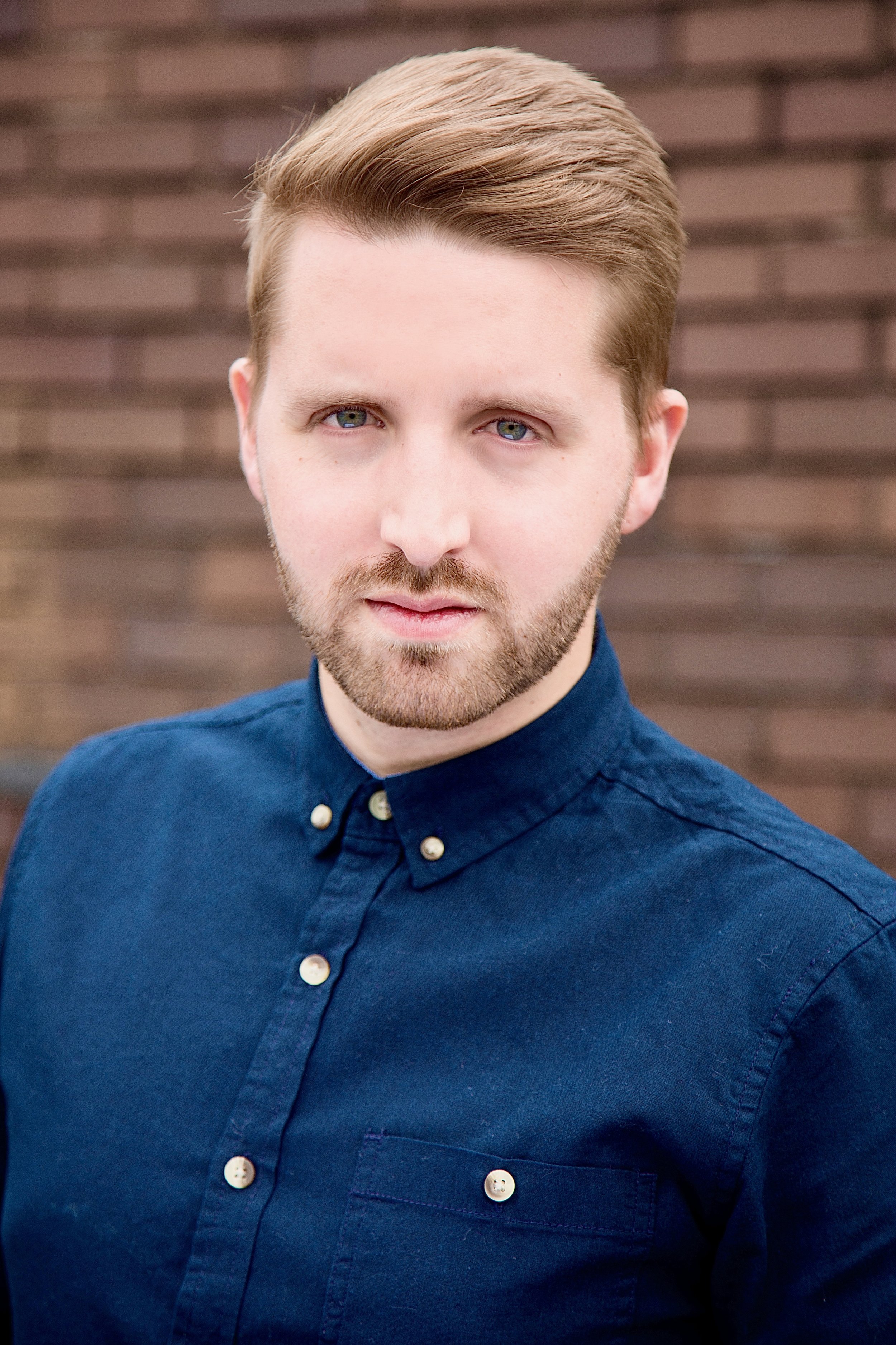 headshot of a man in a blue shirt