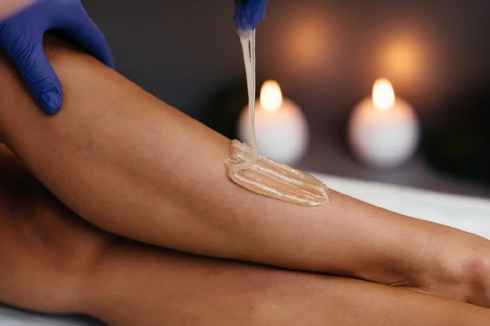 A person receiving a body massage with massage oil, with candles in the background creating a relaxing atmosphere.