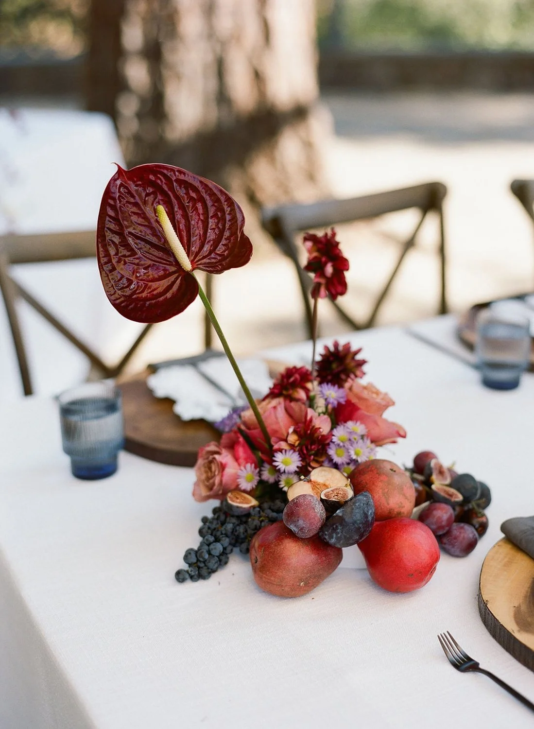 reception-wedding-banquet-tables-still-life-art-floral-design-napa-fruits-berries-roses-anthuriums-moody-dark-red-trendy
