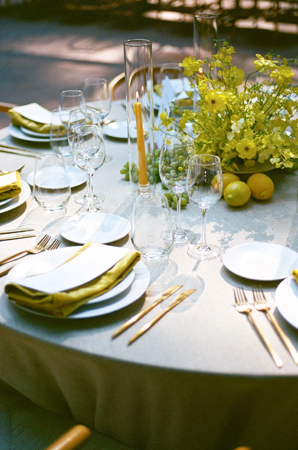 reception-banquet-tables-yellow-oncidiums-ikebana-centerpiece-lemons-grapes-round-table-candles-beeswax-taper