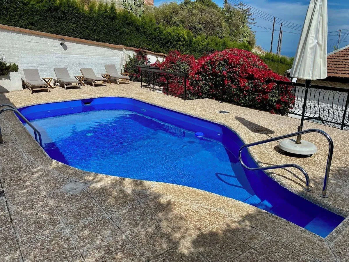 Outdoor heated swimming pool with blue water.