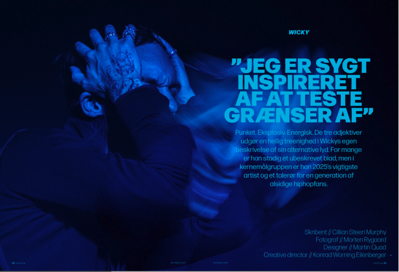 wicky with tattoos on his hands and face holding his head in distress, with dark clothing, in a predominantly blue lighting setting. Gaffa, Jeg er sygt inspireret af at teste grænser af.