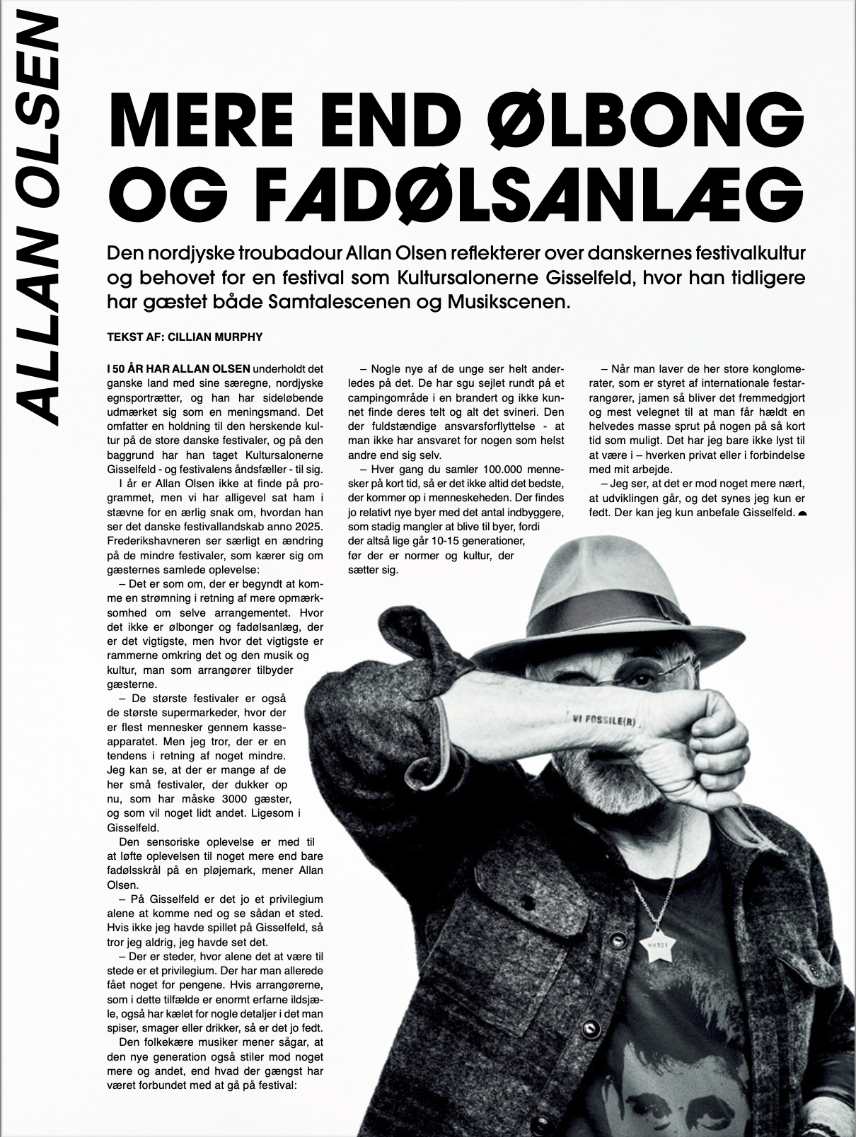 Black and white photo of Allan Olsen with glasses wearing a hat, holding a sign that says 'Vi Fossile(r)', and wearing a star-shaped badge around their neck. "Mere end ølbong og fadølsanlæg".