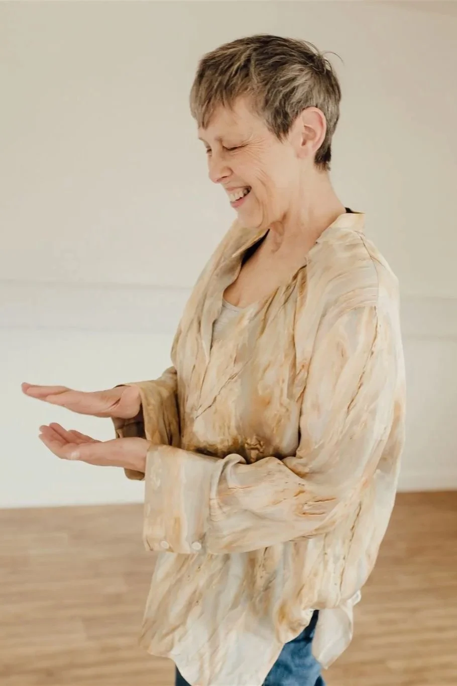 woman smiling in silk shirt hands in gesture