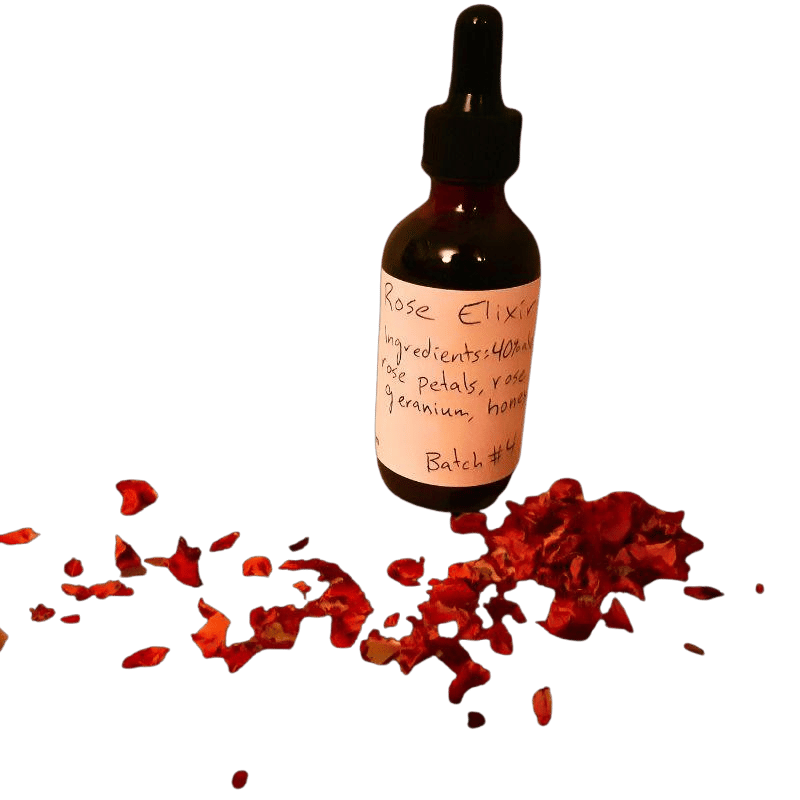A small dark glass dropper bottle labeled 'Rose Elixir' surrounded by scattered rose petals on a green background.