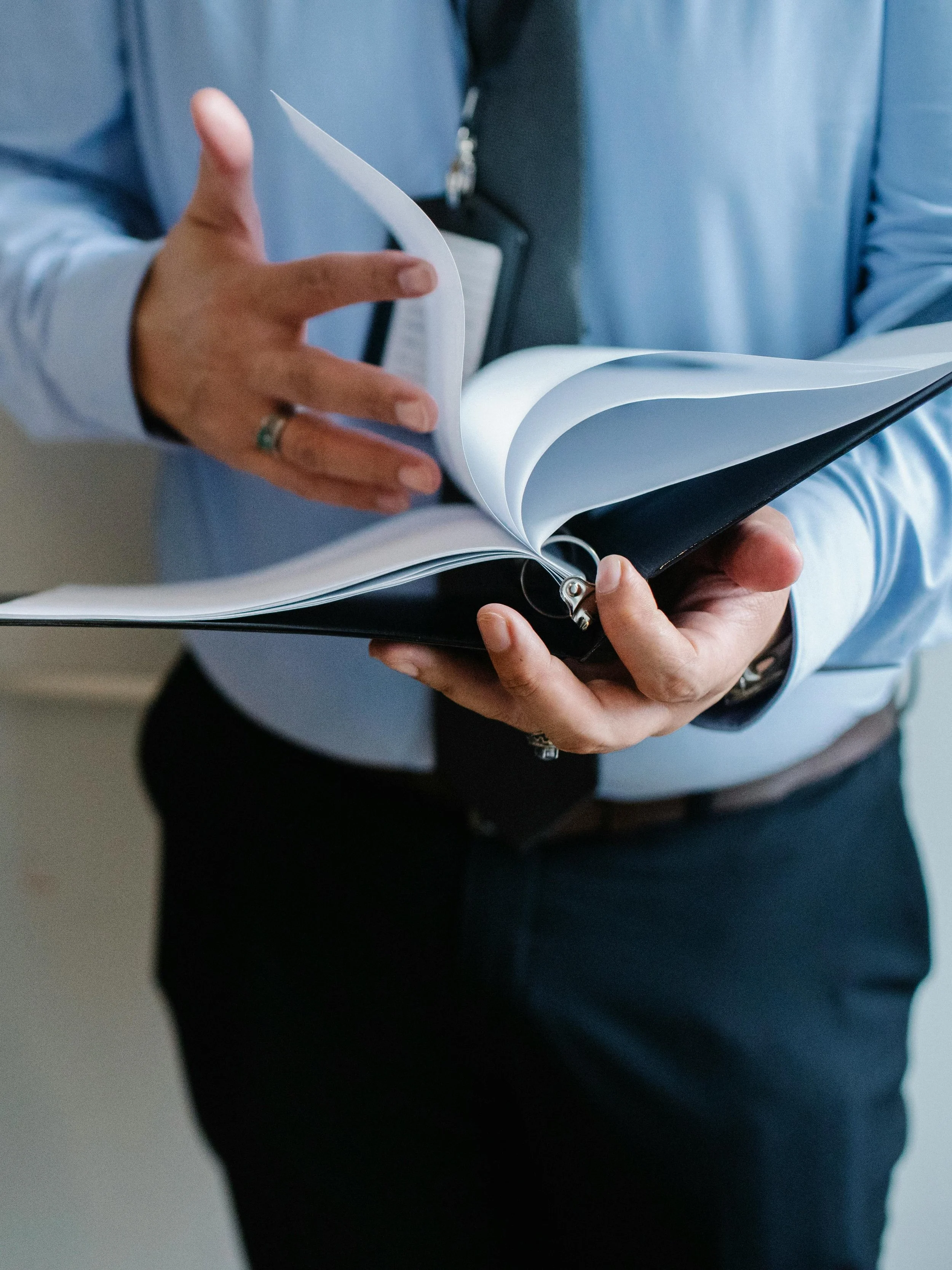 Image of a man reading information in a binder representing the movement from insight to behavior change in executive coaching and leadership development.