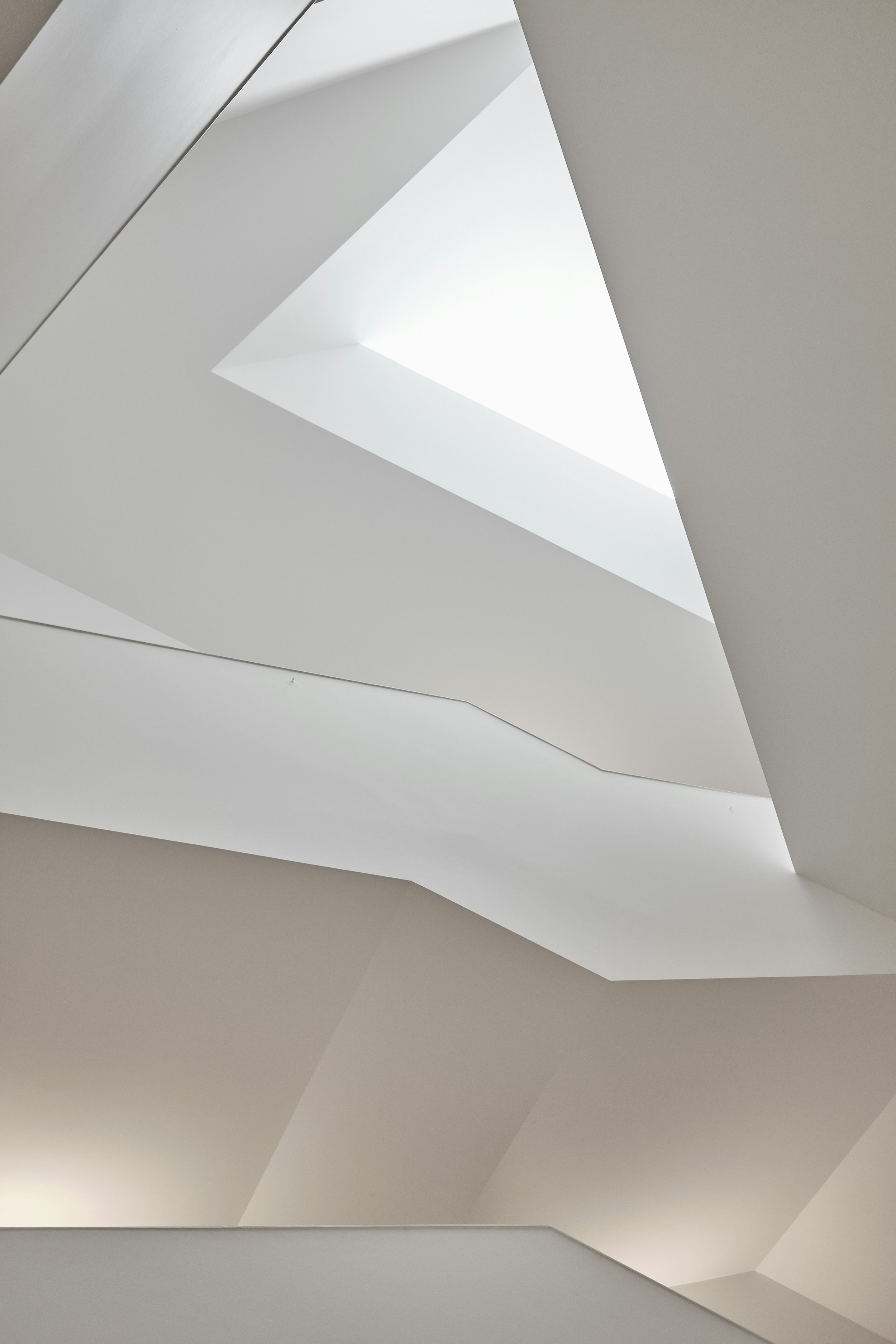 Abstract interior shot of white architectural ceilings with skylight openings.