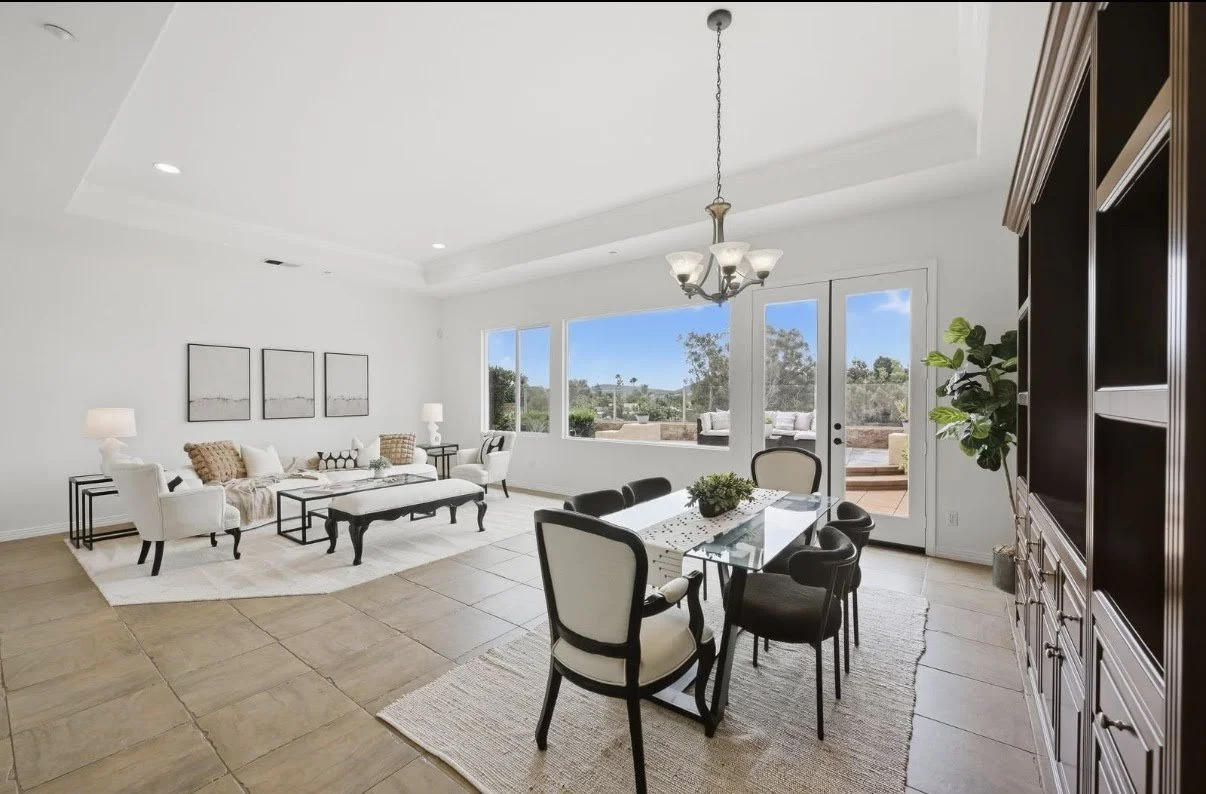 Professionally staged living and dining room by Haus of Heidi in North County San Diego, featuring neutral furnishings, layered rugs, and thoughtfully arranged seating.