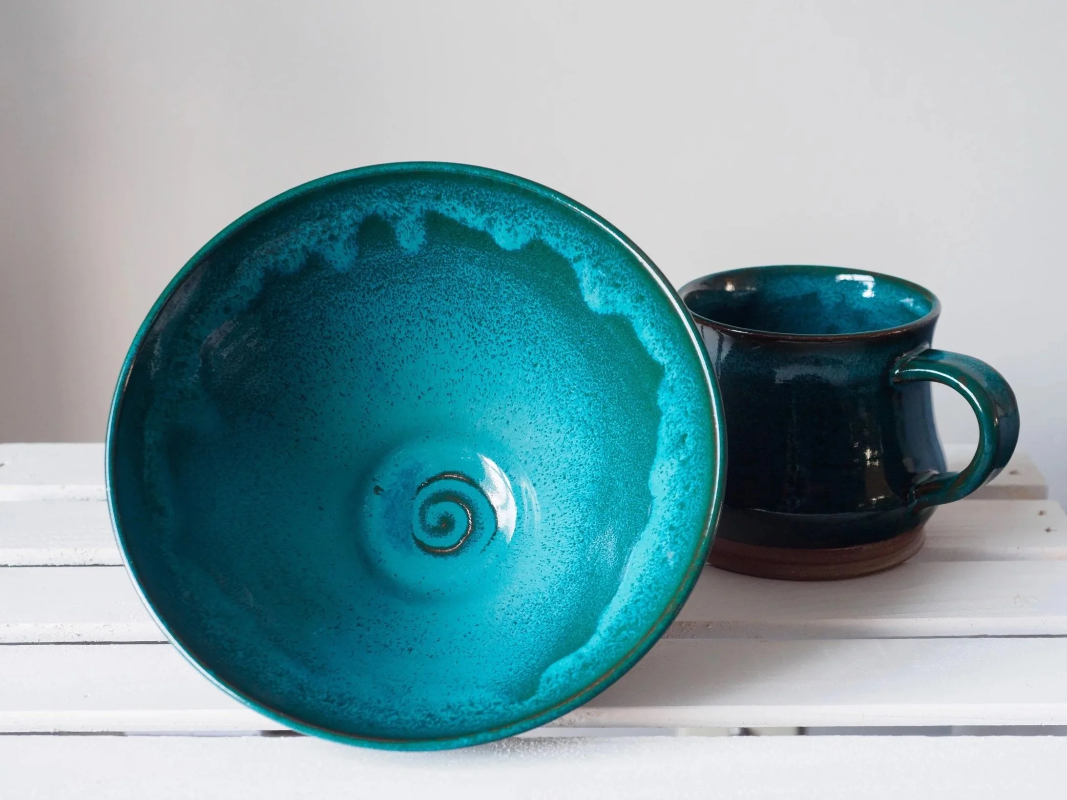 a turquoise ramen bowl sits on its side, displaying the glazed interior