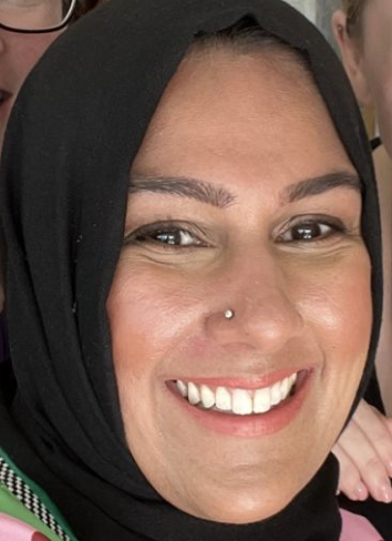 Black and white sketch of a woman with short hair, smiling with an orange star-shaped badge on her shoulder
