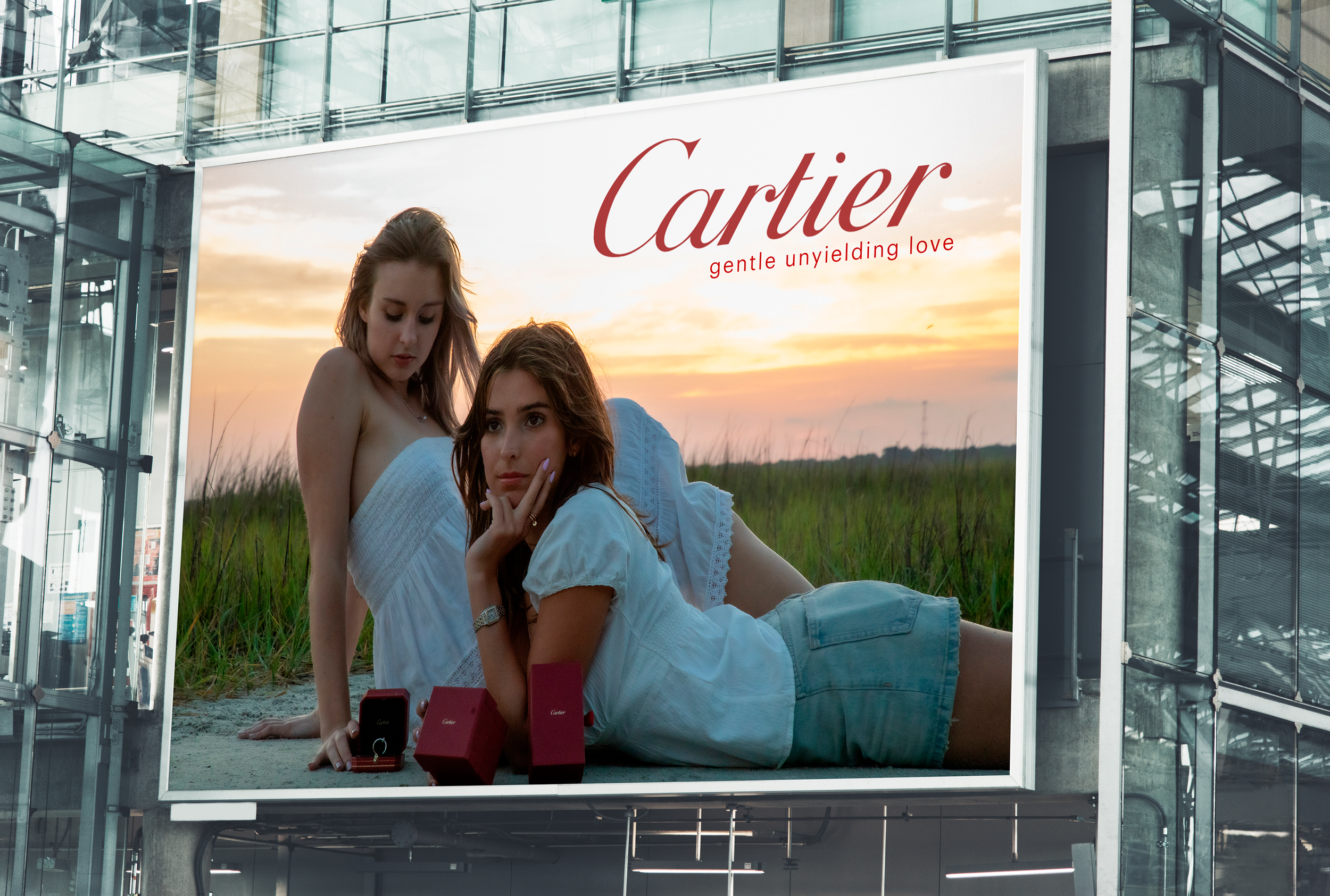 Billboard advertisement for Cartier featuring two women outdoors at sunset, with jewelry displayed in front of them.