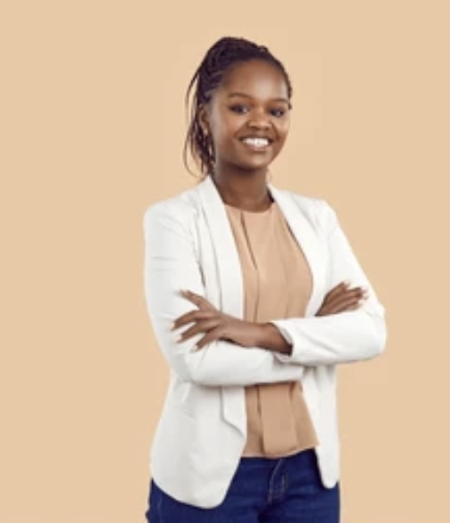 A woman with braided hair smiling, wearing a white blazer over a beige blouse with crossed arms, standing against a peach-colored background.