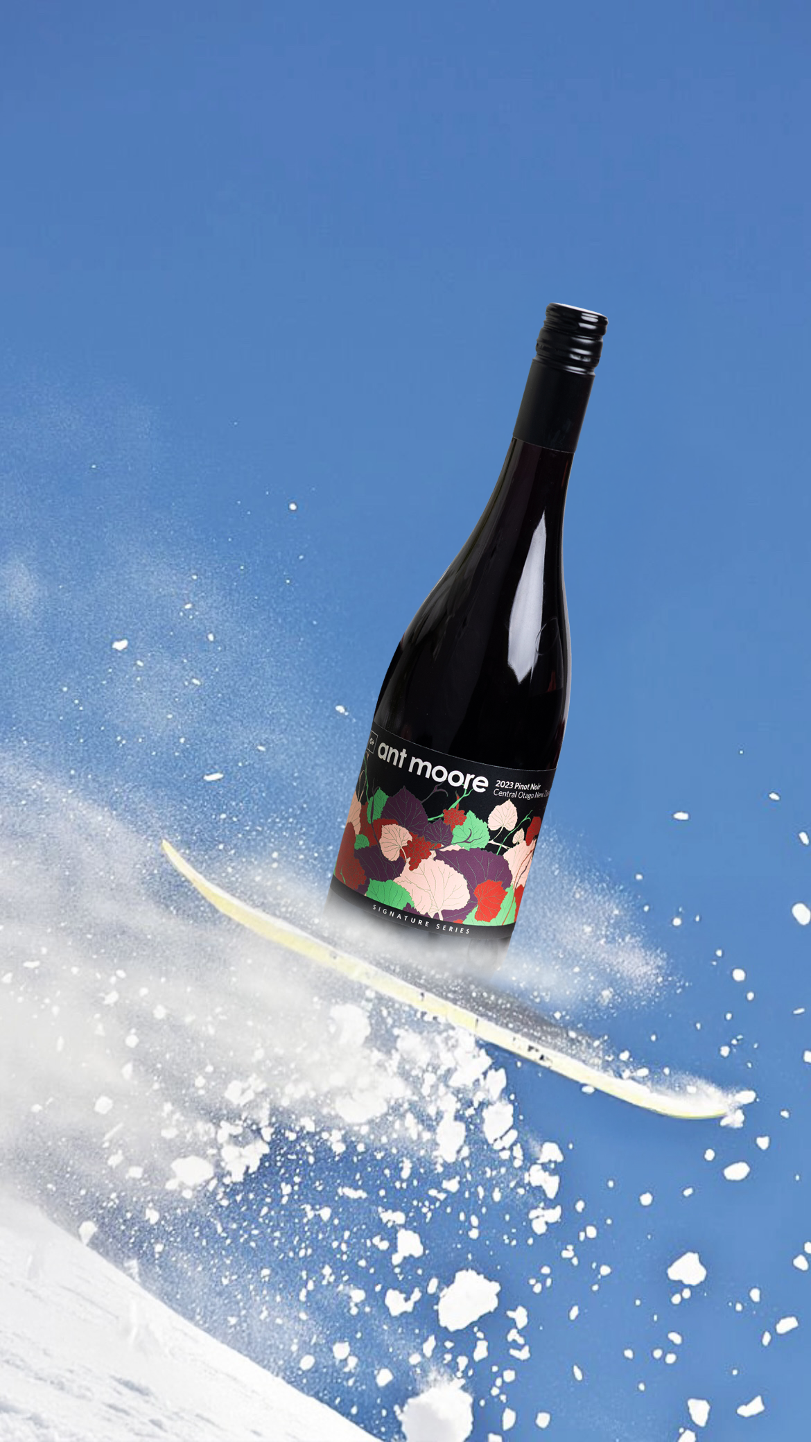 A bottle of Ant Moore 2023 Pinot Noir wine falling through the snow on a ski slope.