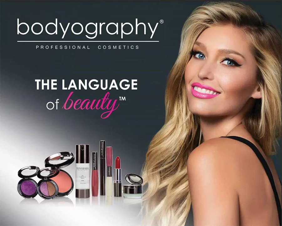 Advertisement for Bodyography professional cosmetics featuring a smiling blonde woman with bright pink lipstick and makeup products including blush, lipstick, eye shadow, and foundation.