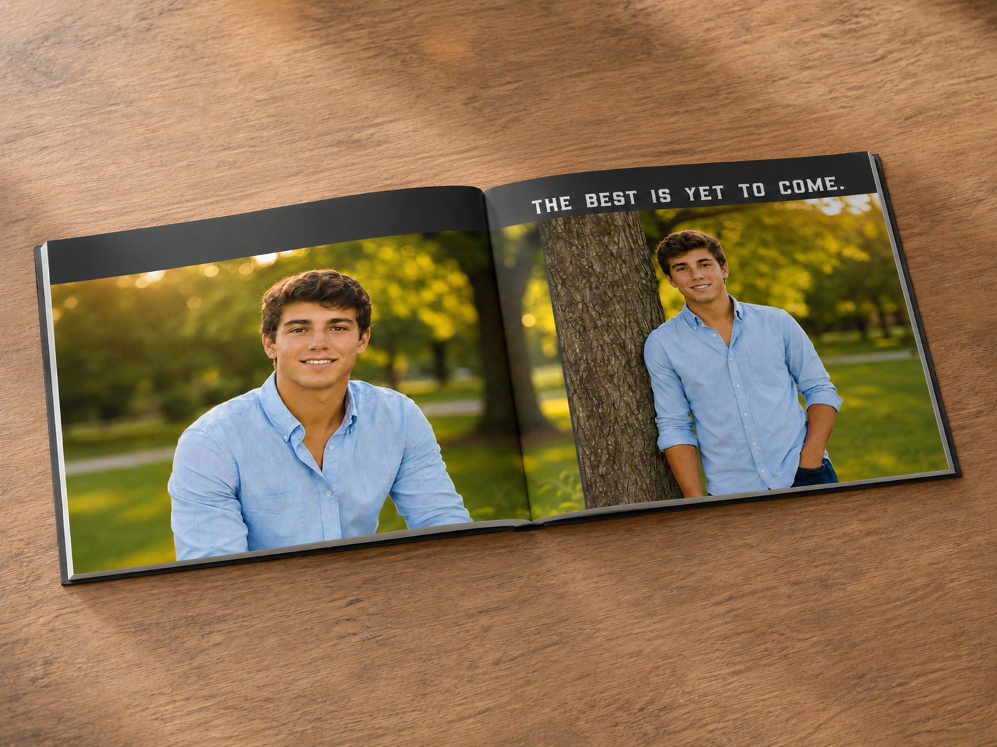 Open hardcover senior photo book lying on a wooden table, featuring two outdoor senior portraits of a young man in a light blue shirt with the words “The Best Is Yet to Come.”