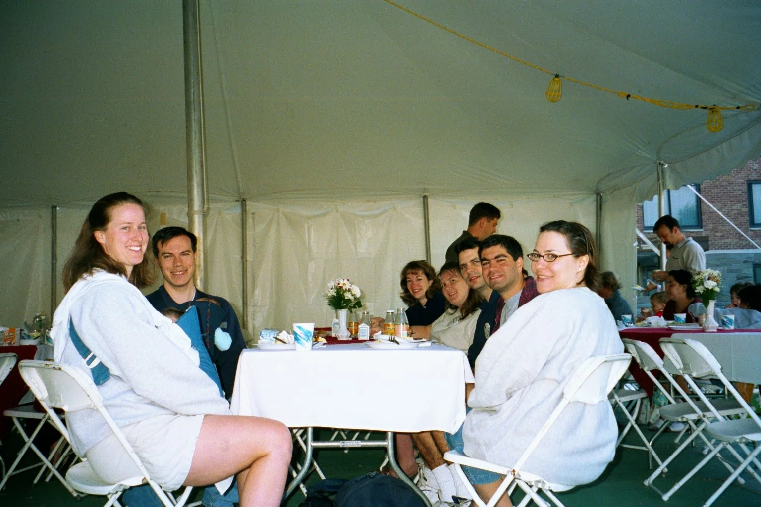 People sitting at a table under a white tent