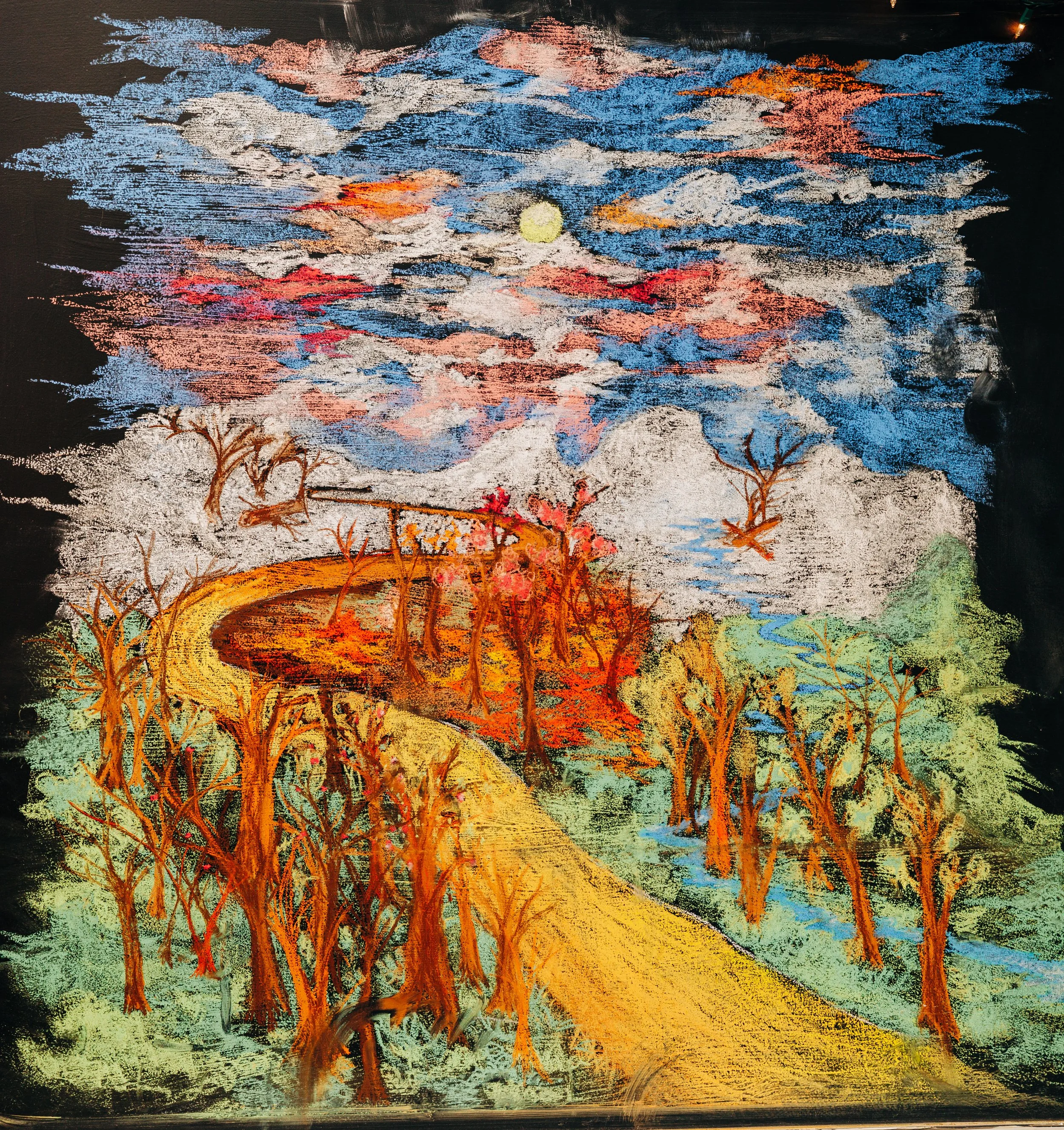 Colorful landscape painting featuring a winding yellow path, leafless orange trees, a small stream, and a bright sky with clouds and a yellow sun.