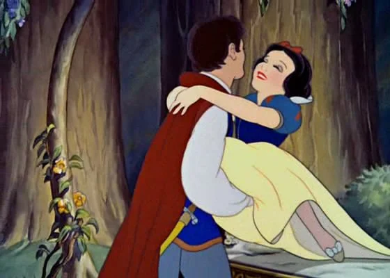 Disney's Snow White being carried by a prince in a forest.