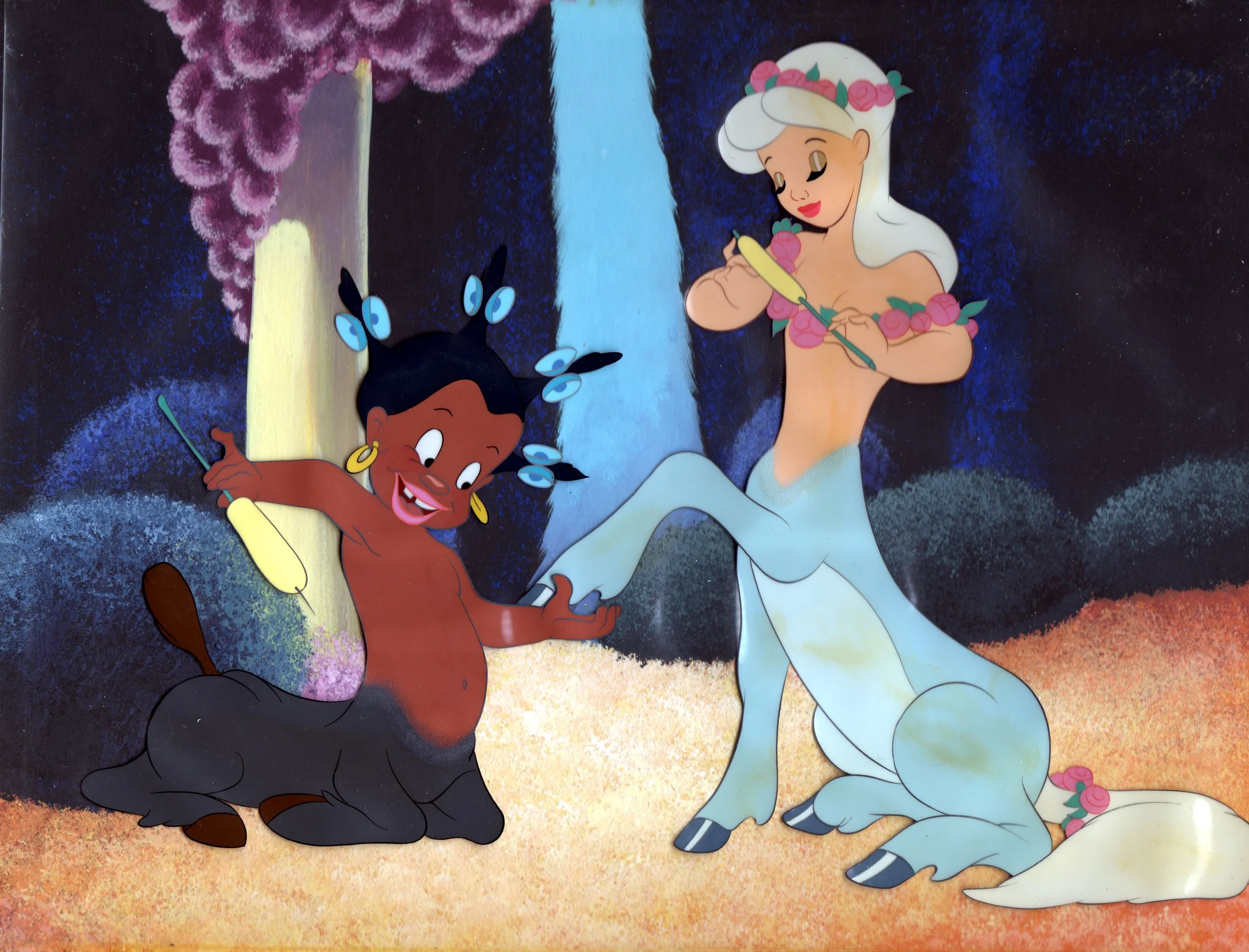 Animated scene featuring a black woman with butterfly-like hair and a mermaid with a flower crown, alongside a white unicorn with pink roses on its head, in a colorful, fantasy setting.