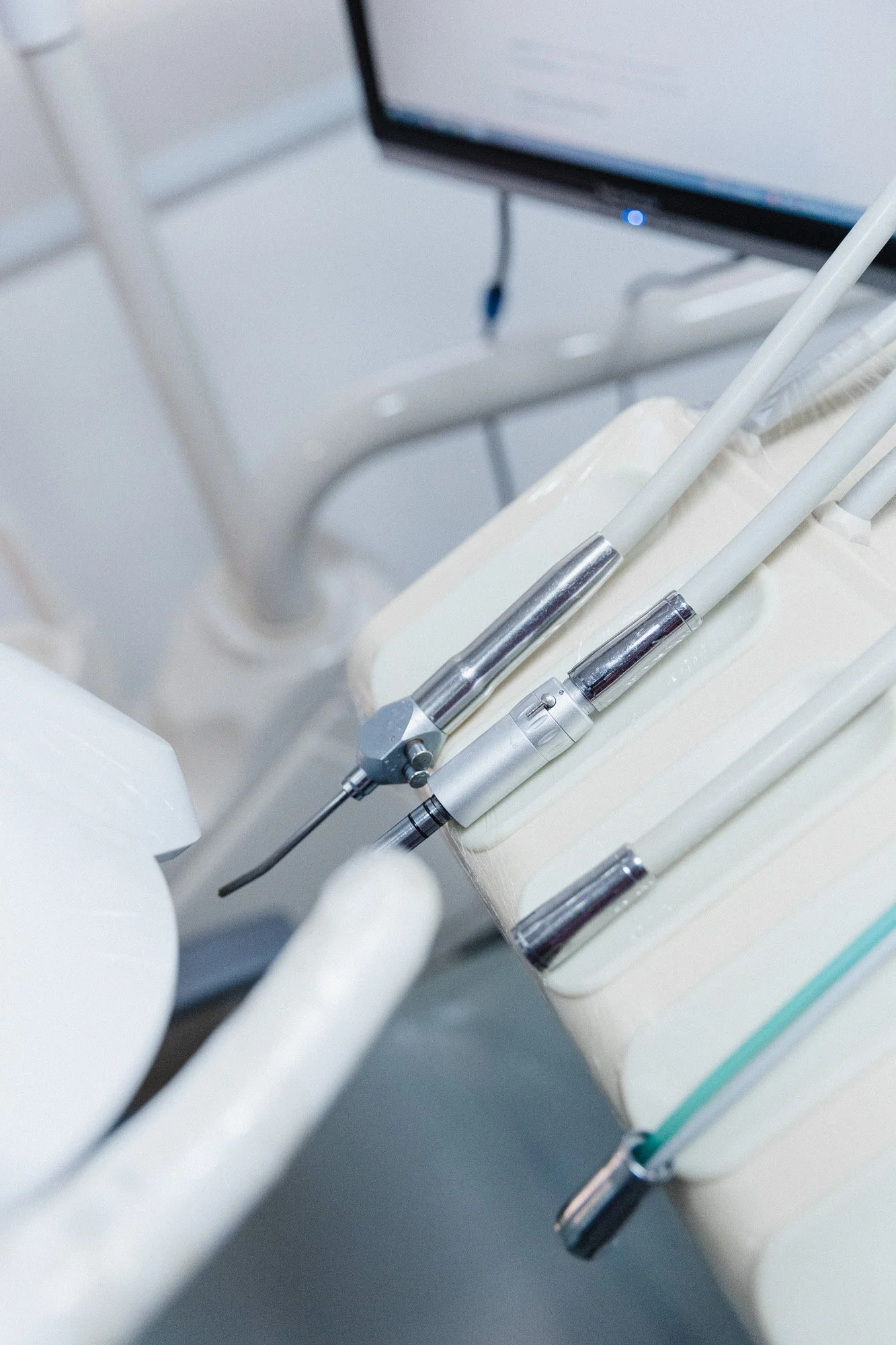 Instrumentos dentales en una clínica dental frente a una pantalla de computadora