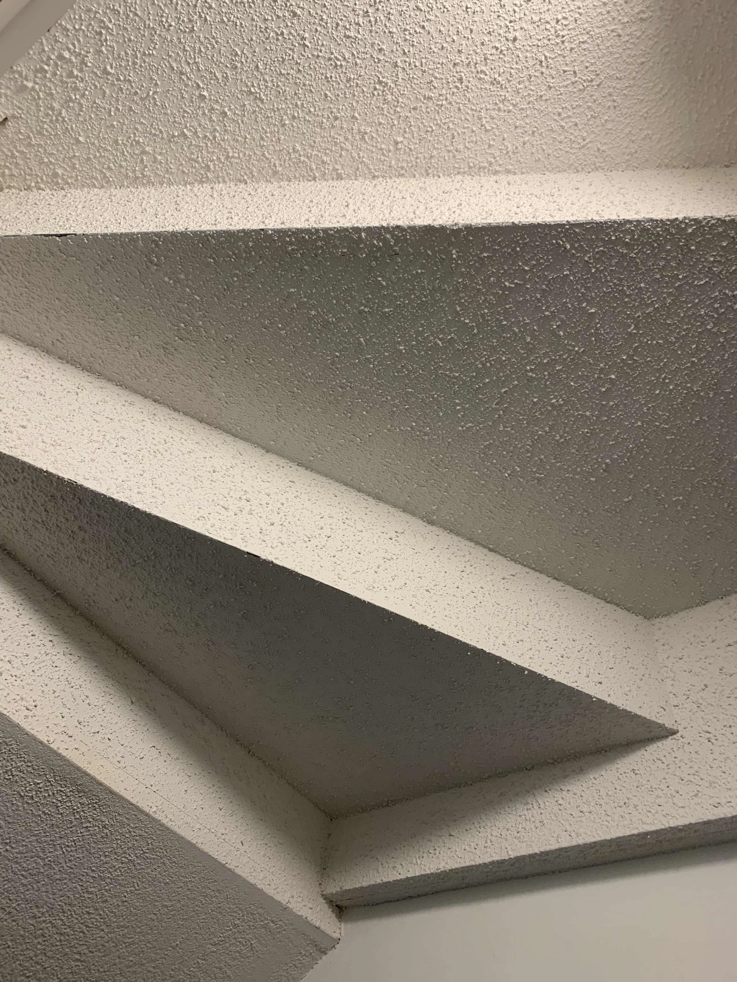 Bedroom ceiling in a home showing popcorn ceiling before it's removed.