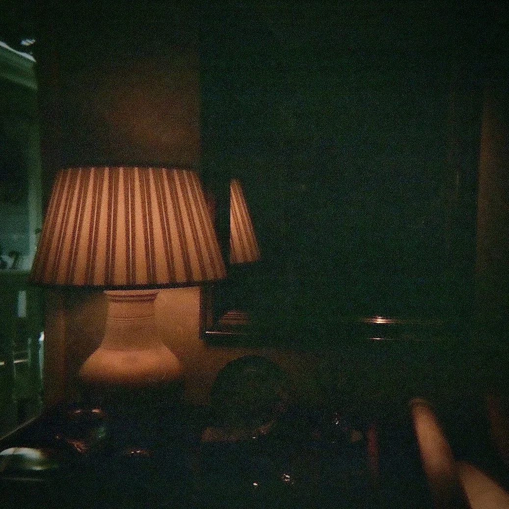 Dimly lit room with a table lamp featuring a striped lampshade.