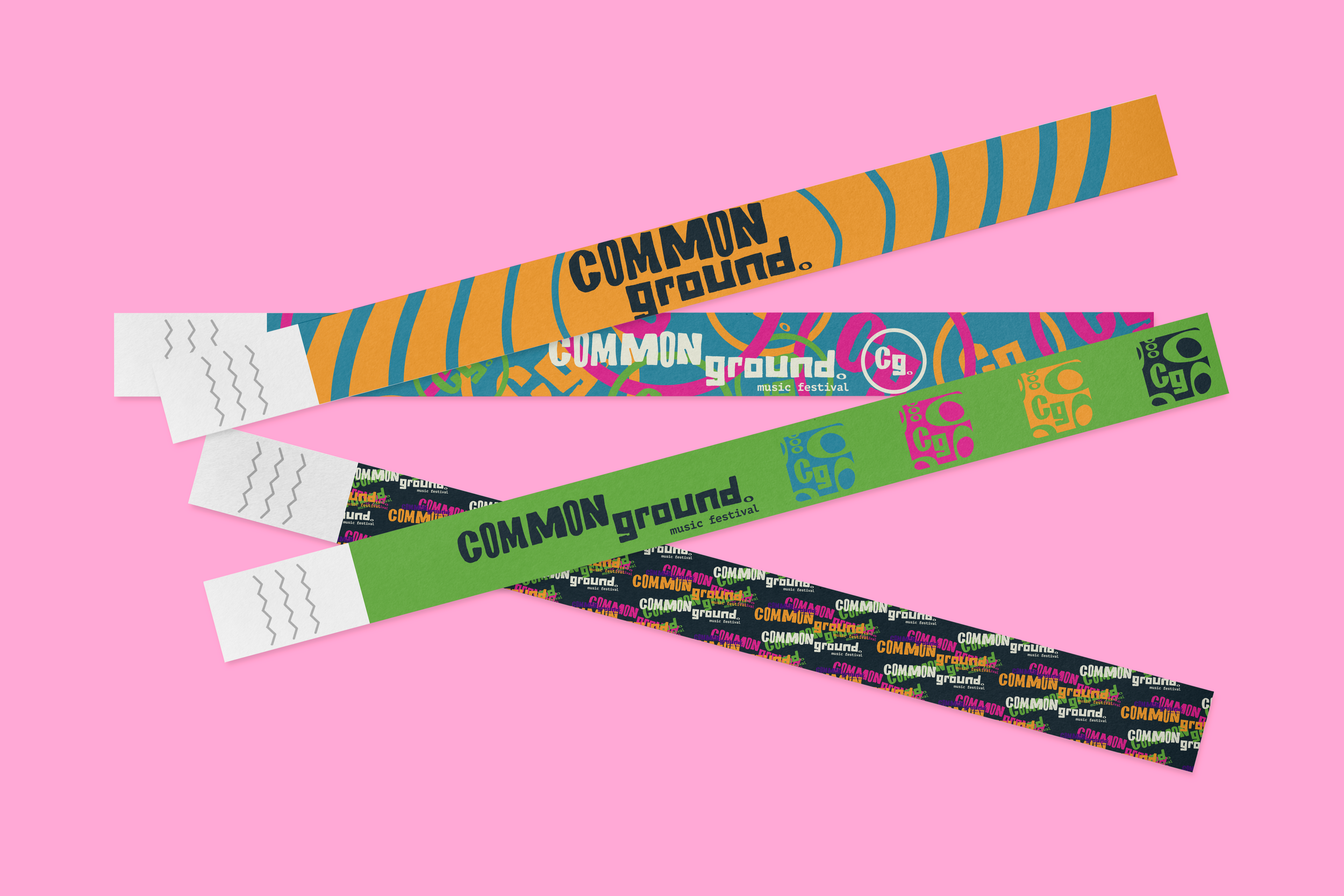 Colorful wristbands with 'Common Ground' and 'music festival' printed on them, placed on a pink background.