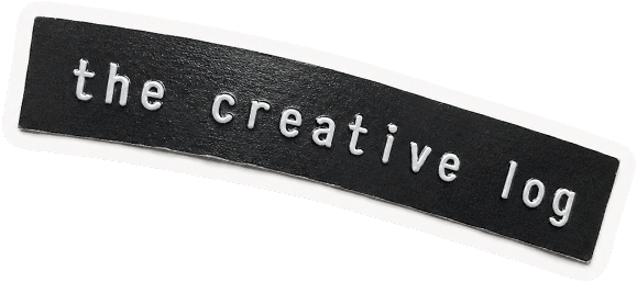 Close-up of a patch with the text 'the creative log' on a black background.