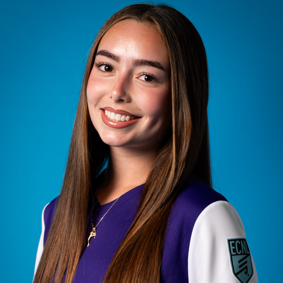 A young woman with long brown hair, smiling, wearing a purple and white sports jersey with an 'ECM' logo on the sleeve, against a blue background.