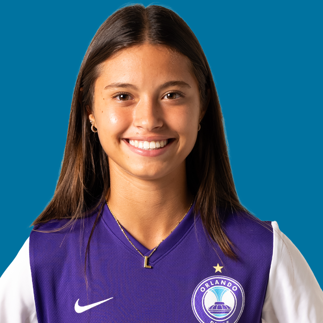 Young woman smiling, wearing Orlando Pride soccer jersey with Nike logo
