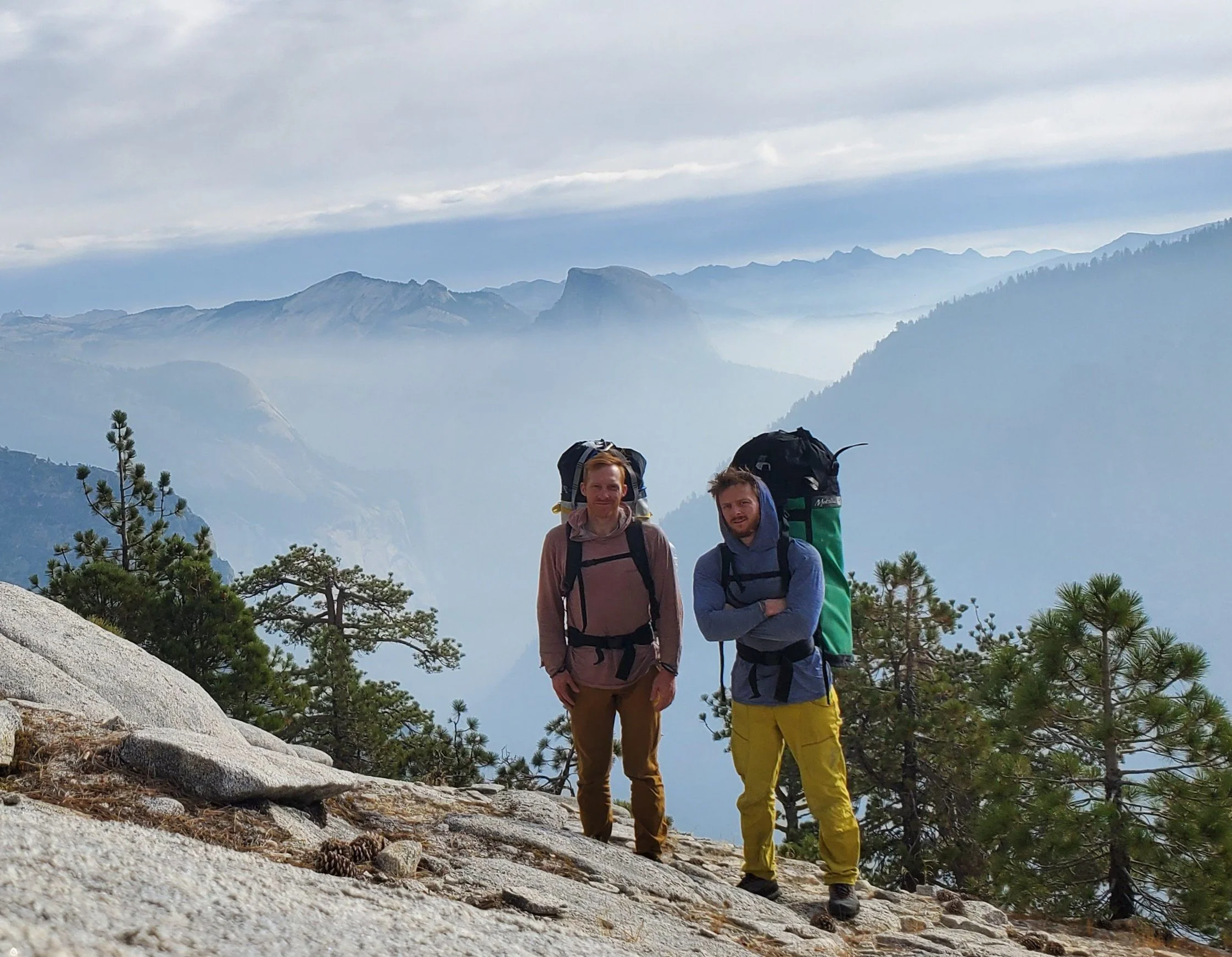 The two owners of Apex Consultants after climbing El Capitan with 150lb haul bags strapped to their backs and a misty view of half dome in the background.