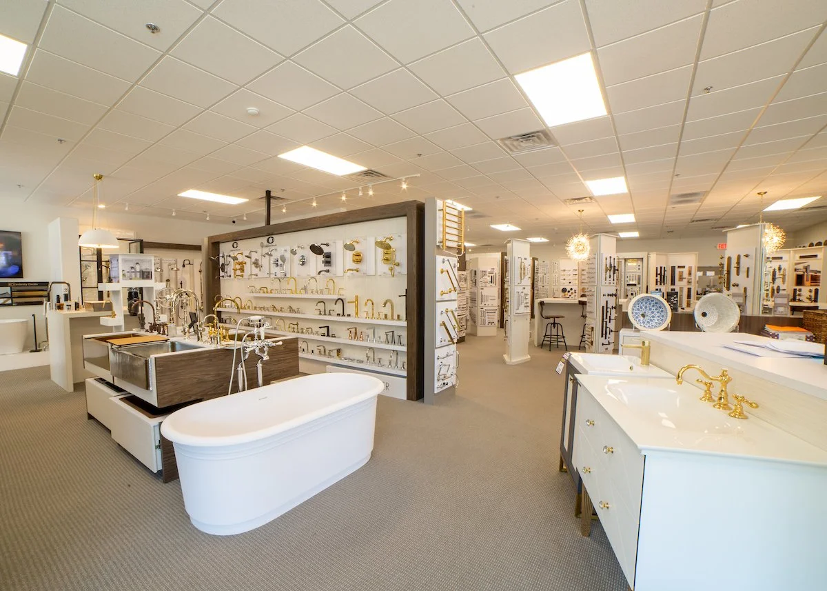 Display of bathroom fixtures including bathtubs, sinks, and faucets in a home improvement store.