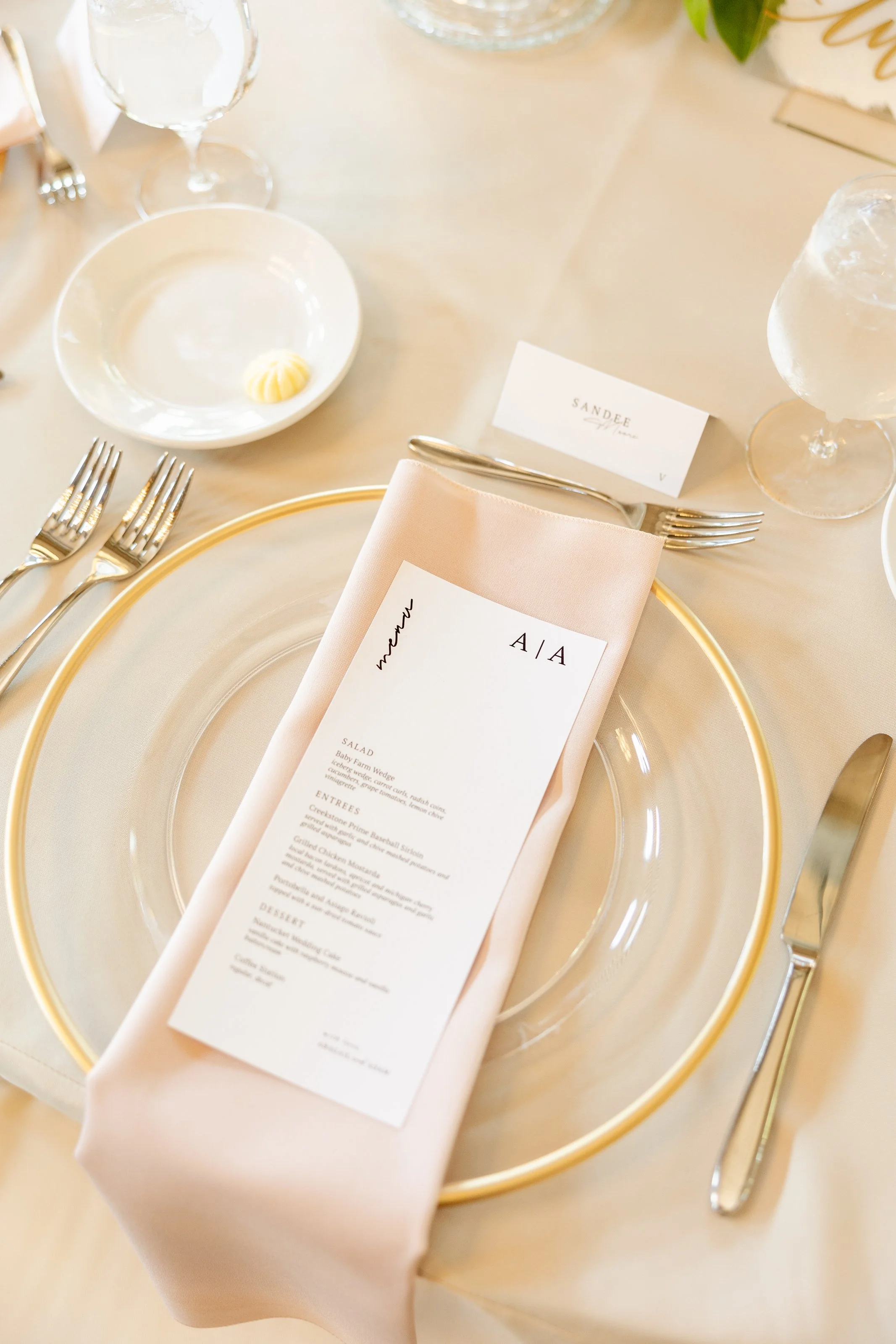 Michigan wedding tablescape with gold charger plate, blush napkin, and printed menu detail