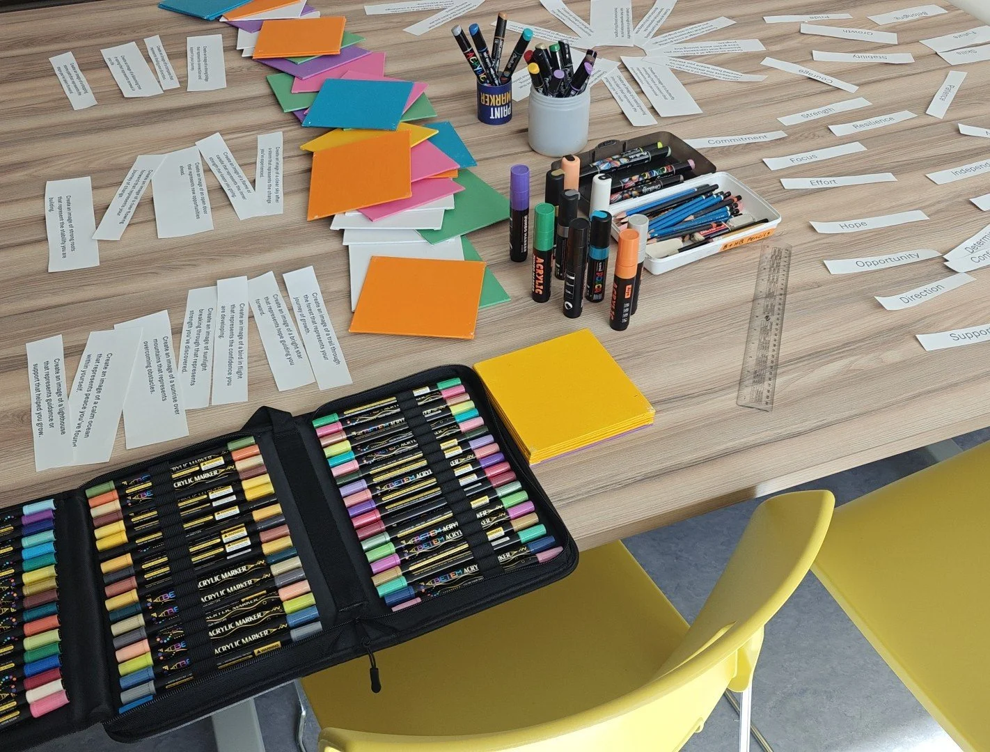 Staff wellness workshop facilitated by art therapist, Jennifer Kleinsteuber with colorful canvas, various colored markers, pens, and papers with words like 'Opportunity', 'Effort', and 'Support' written on them.