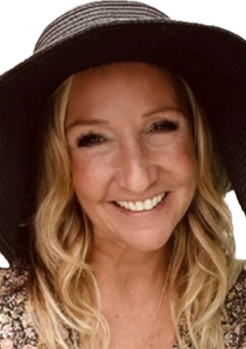 A woman with blonde wavy hair, wearing a wide-brimmed hat, smiling