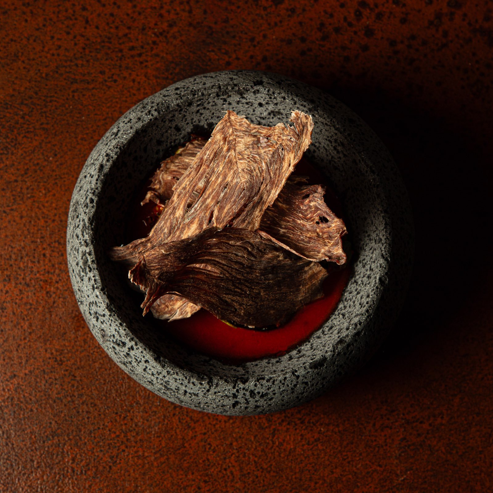 Aguachile rosa con carne seca servido en molcajete de piedra, botana de Mecenas Bar