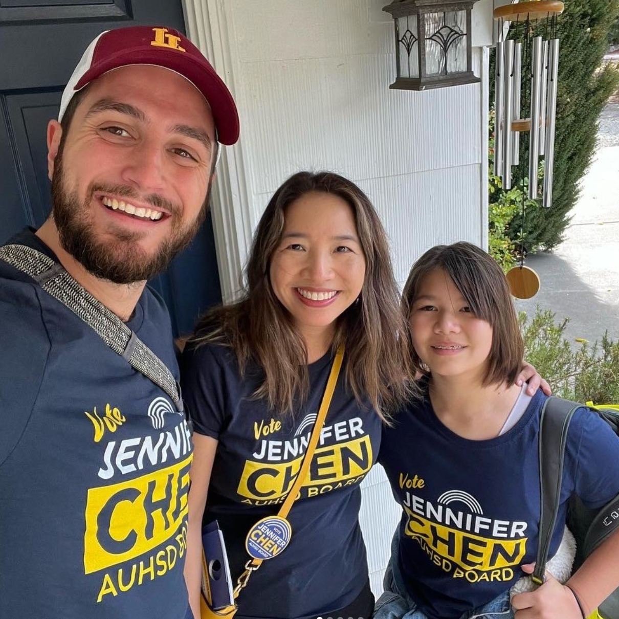 Three people smiling and taking a selfie: two adults and one child. They are wearing campaign shirts supporting Jennifer Chen for Acalanes Unified High School District board.