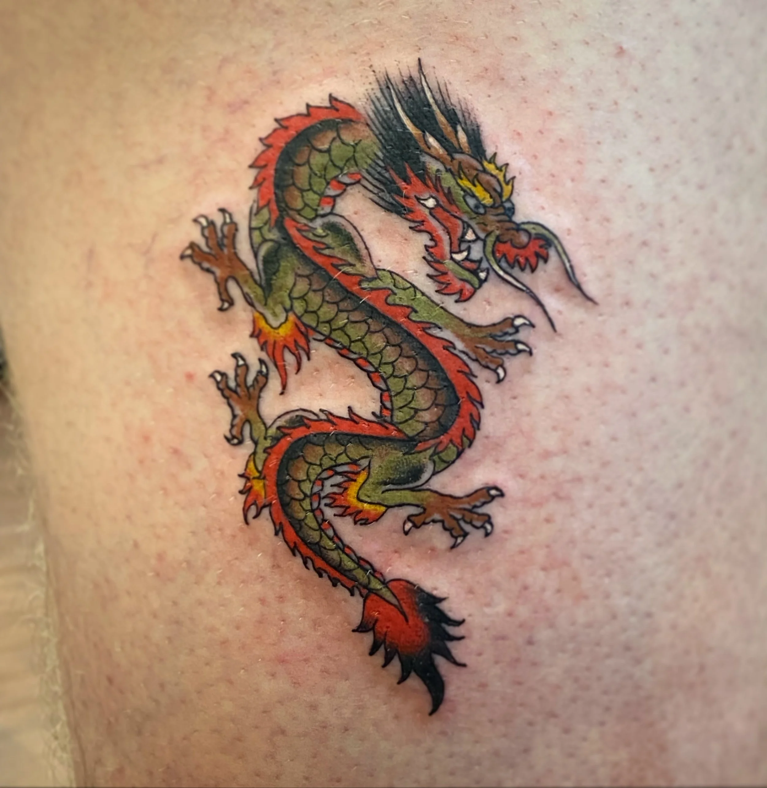 Colorful tattoo of a dragon on a person's skin.
