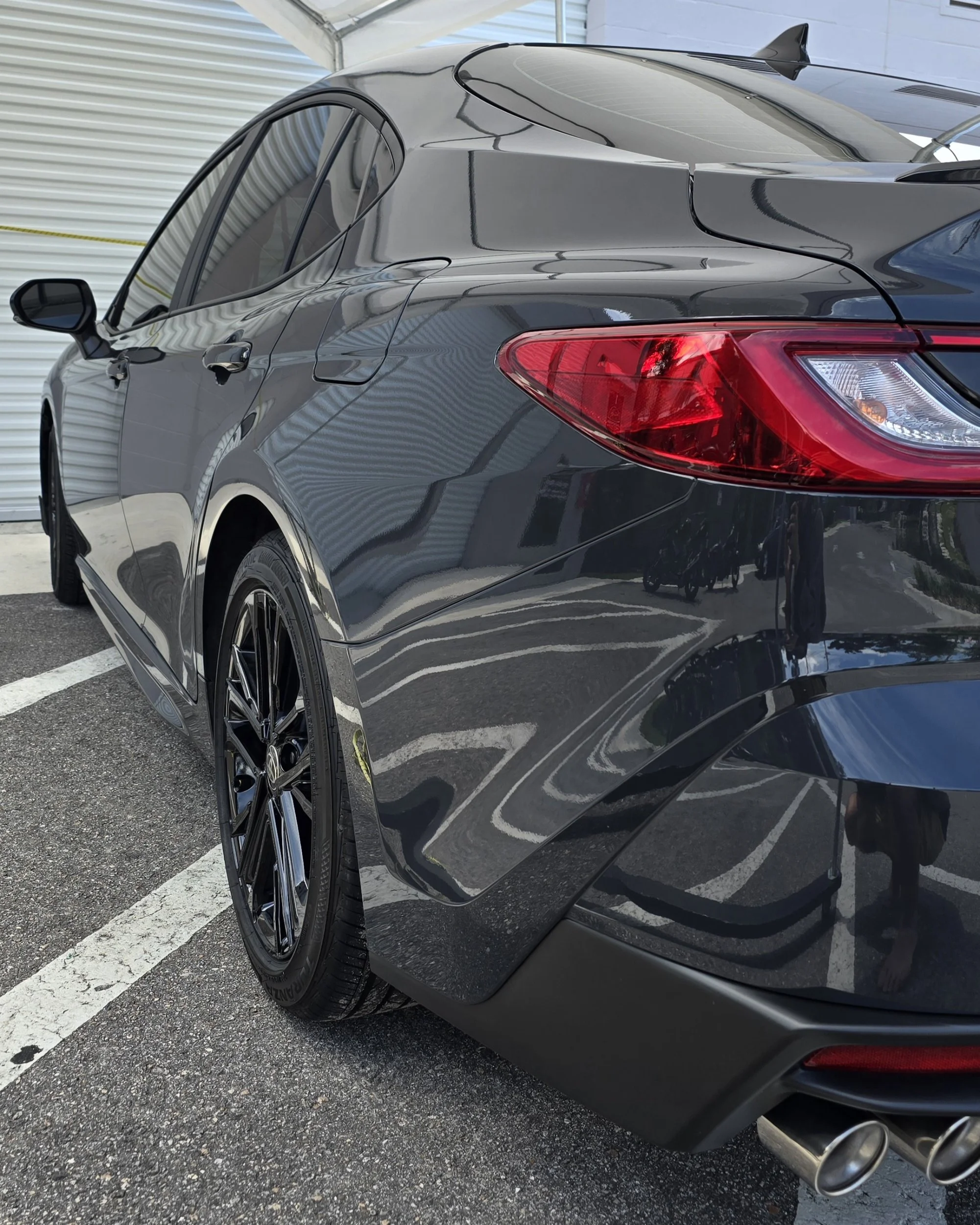 Dark gray toyota camry after a one step paint correction and 7-year ceramic coating parked in front of shop