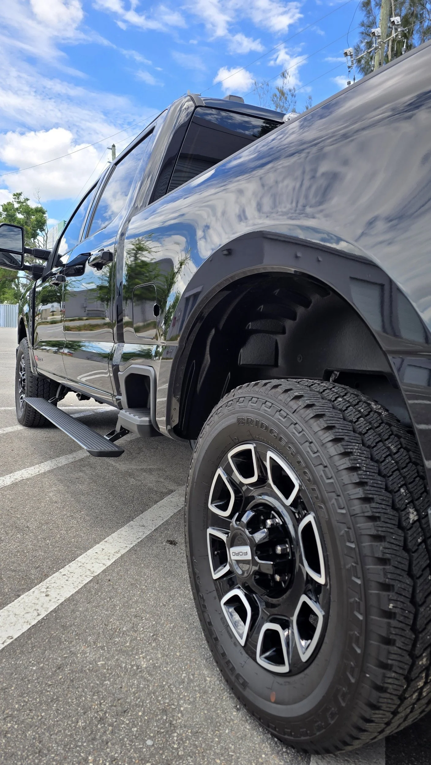 Glossy black mirror finish Ford F-250 Super Duty after a premium paint correction and 25-year self-healing ceramic coating by Miyagi Motorworks for a Belleair FL client.